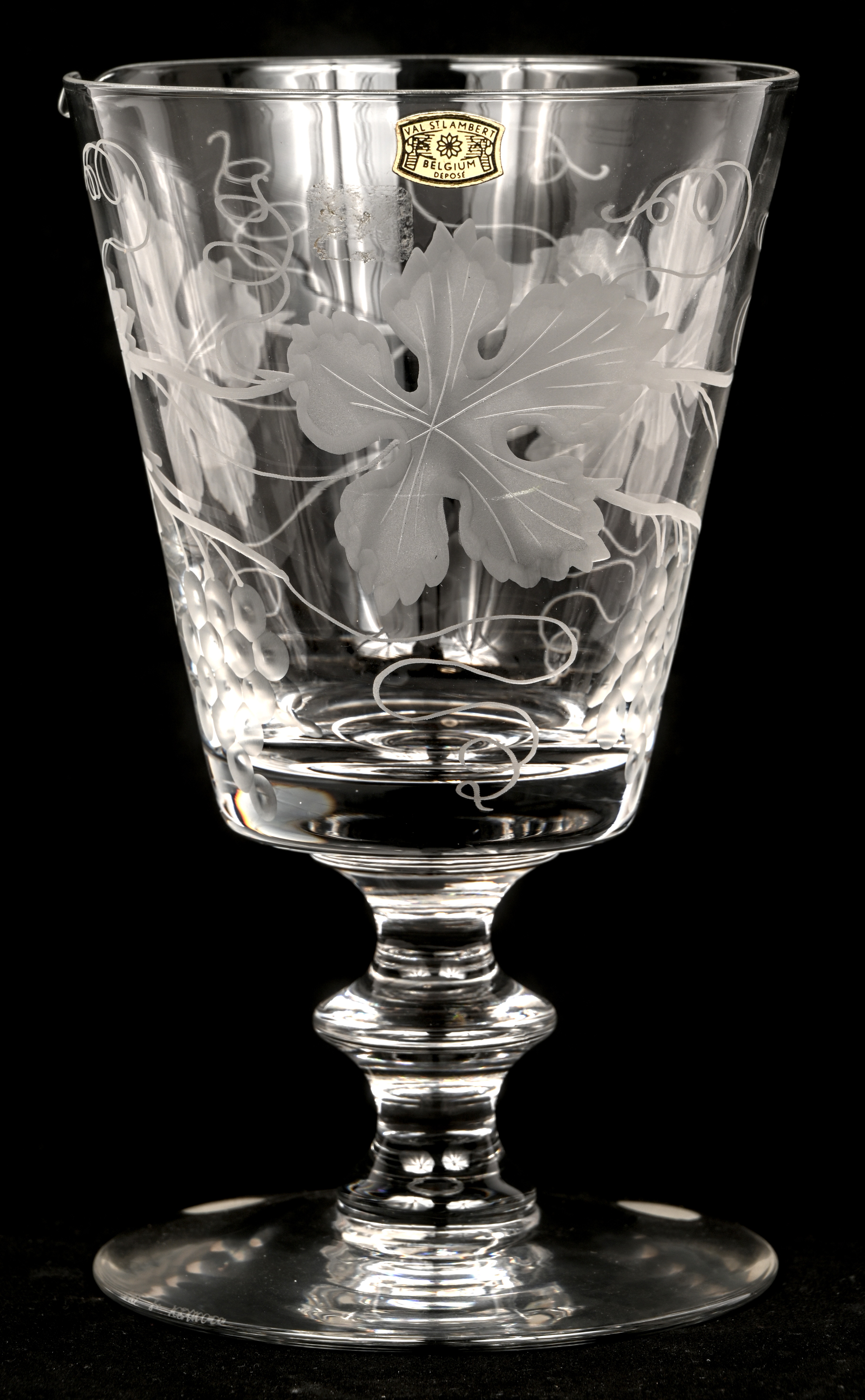 Een grote kelk van kleurloos kristal met een gegraveerd decor van wijnbladeren. Getekend en gemerkt met sticker Een grote kelk van kleurloos kristal met een gegraveerd decor van wijnbladeren. Getekend en gemerkt met sticker.