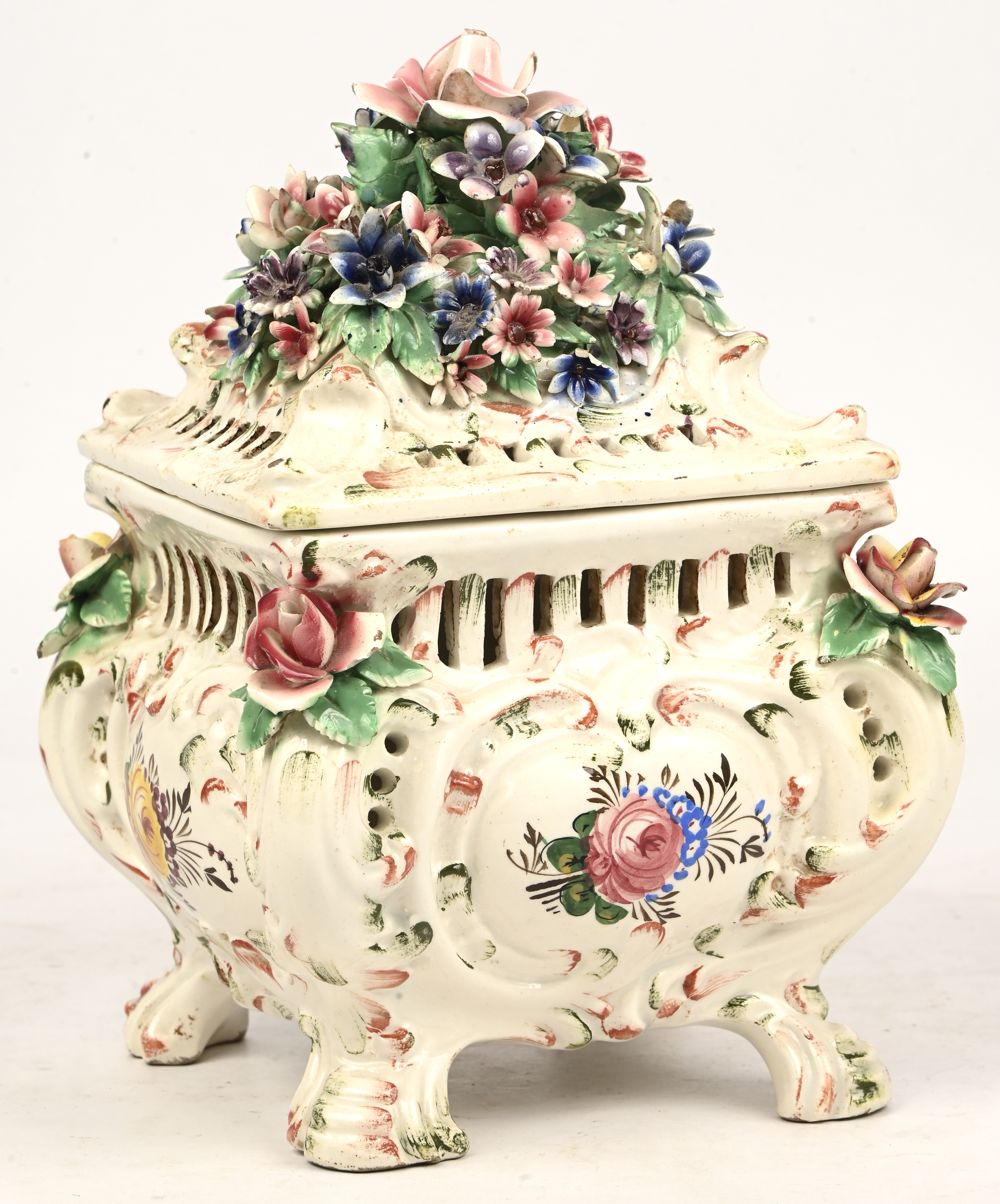Een opengewerkt porseleinen dekselpotje versierd met bloemen, in de stijl van Capodimonte. Met schade Een opengewerkt porseleinen dekselpotje versierd met bloemen, in de stijl van Capodimonte. Met schade.