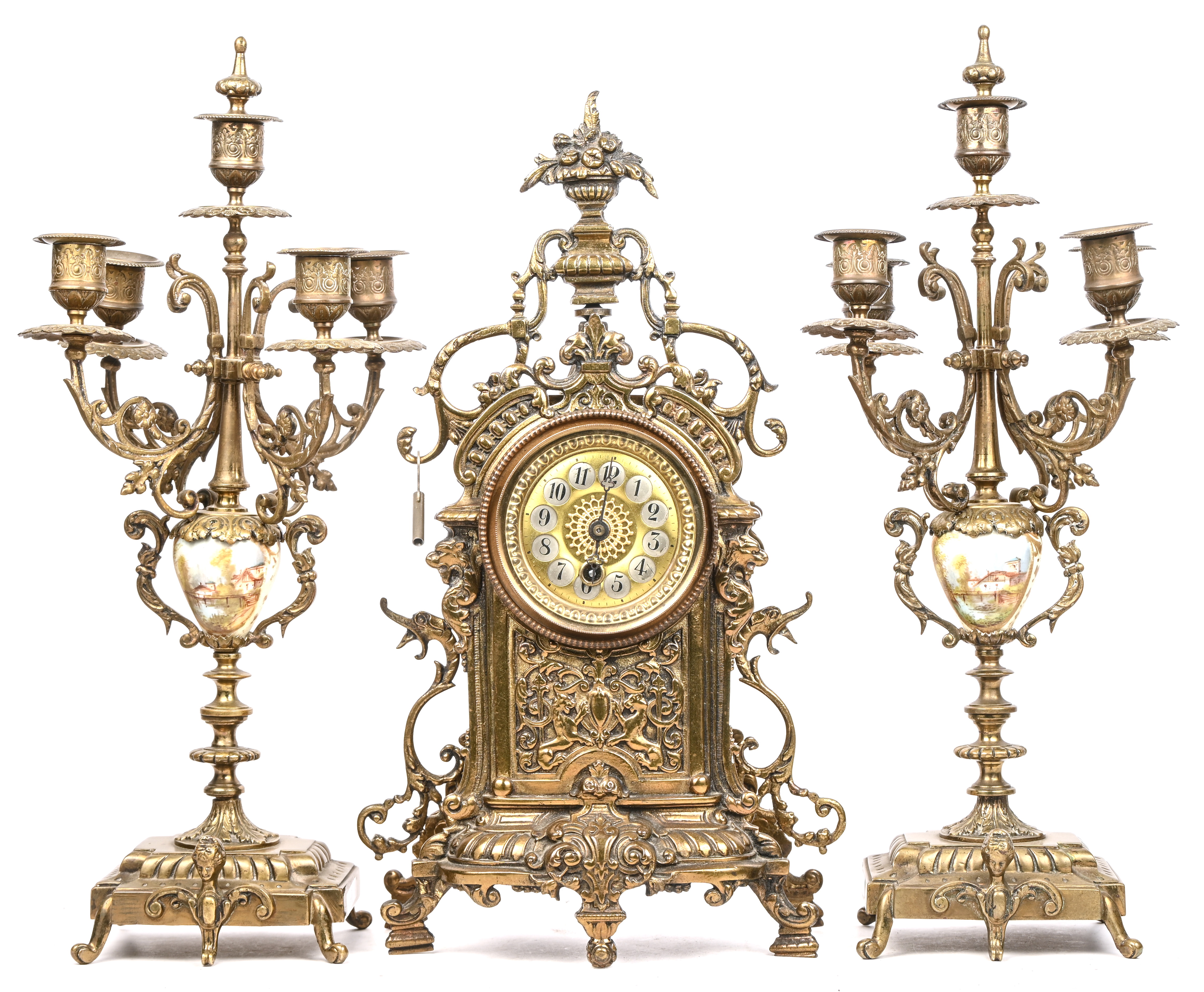 Een bronzen mantelklok in barokke stijl, toegevoegd een paar kandelaars Een bronzen mantelklok in barokke stijl, toegevoegd een paar kandelaars.