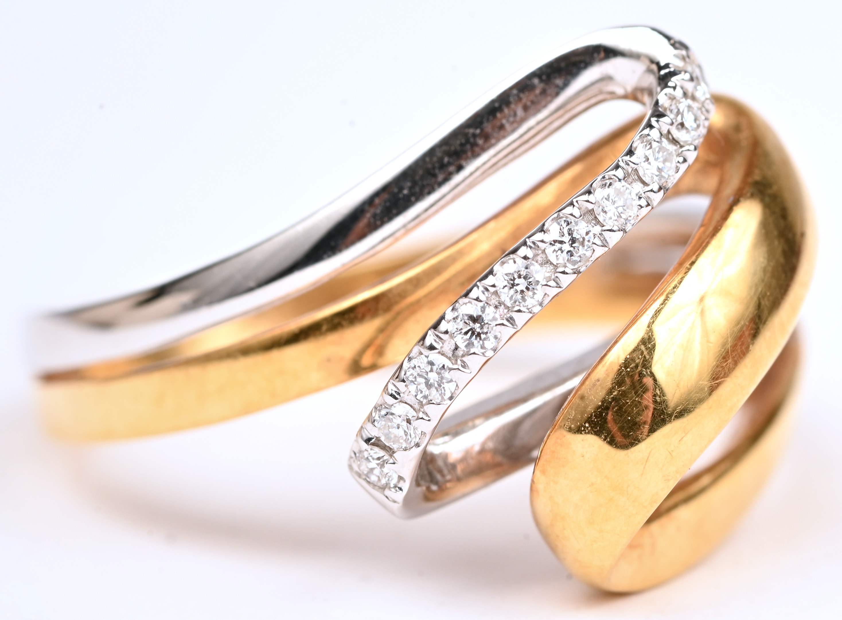 Een 18 kt wit- en geelgouden ring bezet met briljanten van een gezamenlijk gewicht van 0,10 ct Een 18 kt wit- en geelgouden ring bezet met briljanten van een gezamenlijk gewicht van 0,10 ct.