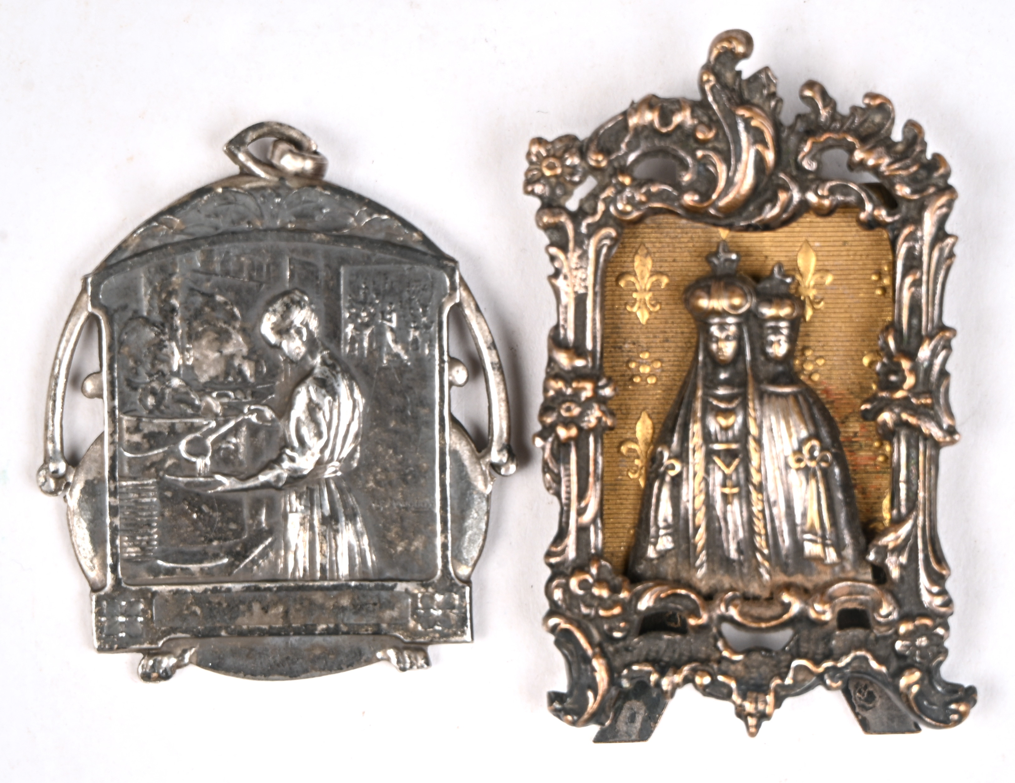 Een penning (S.M. Antwerps noenmaal 1916) en een klein verzilverd religieus object Een penning (S.M. Antwerps noenmaal 1916) en een klein verzilverd religieus object.