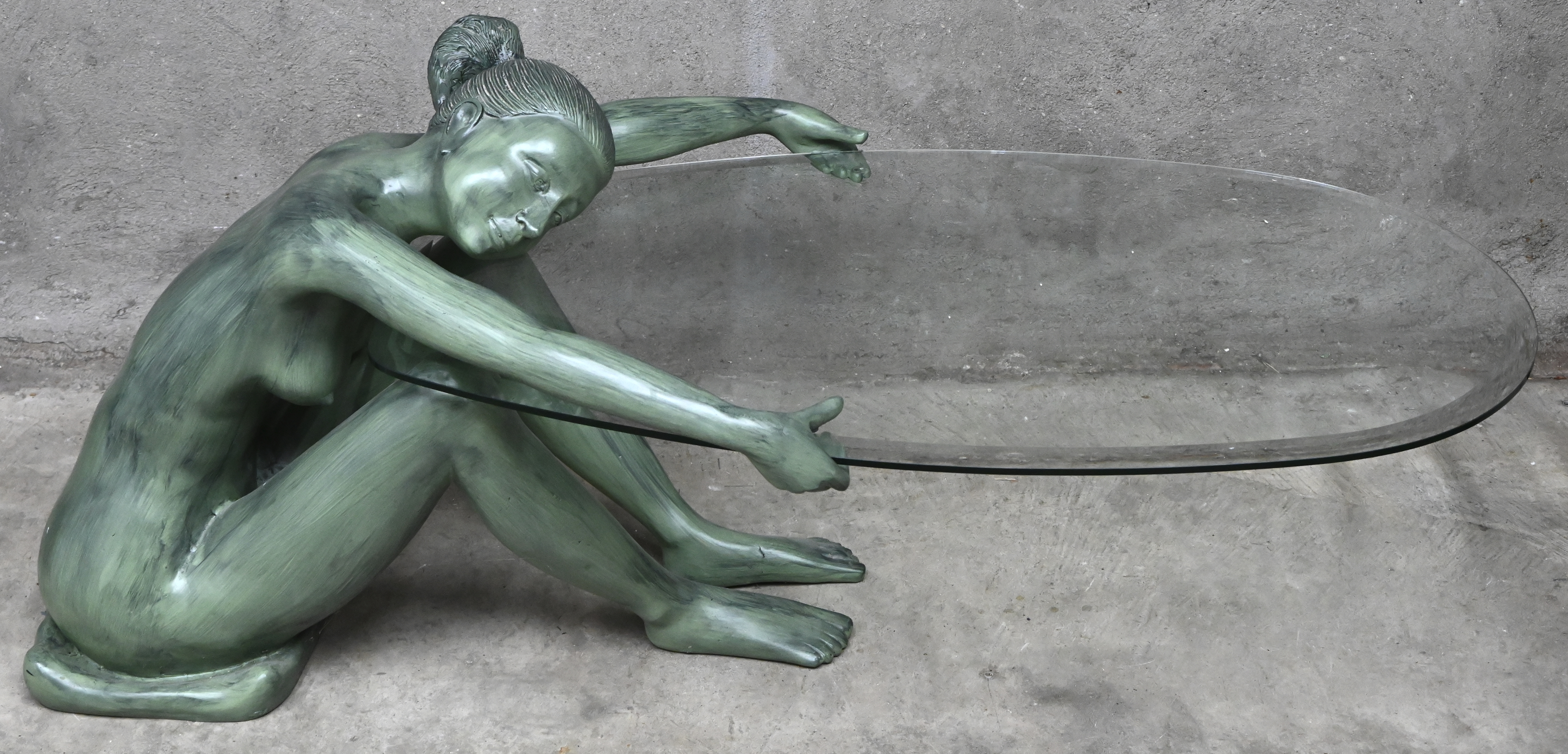 Een salontafel samengesteld uit een naakte bronzen ballerina met een geslepen glazen blad Een salontafel samengesteld uit een naakte bronzen ballerina met een geslepen glazen blad.