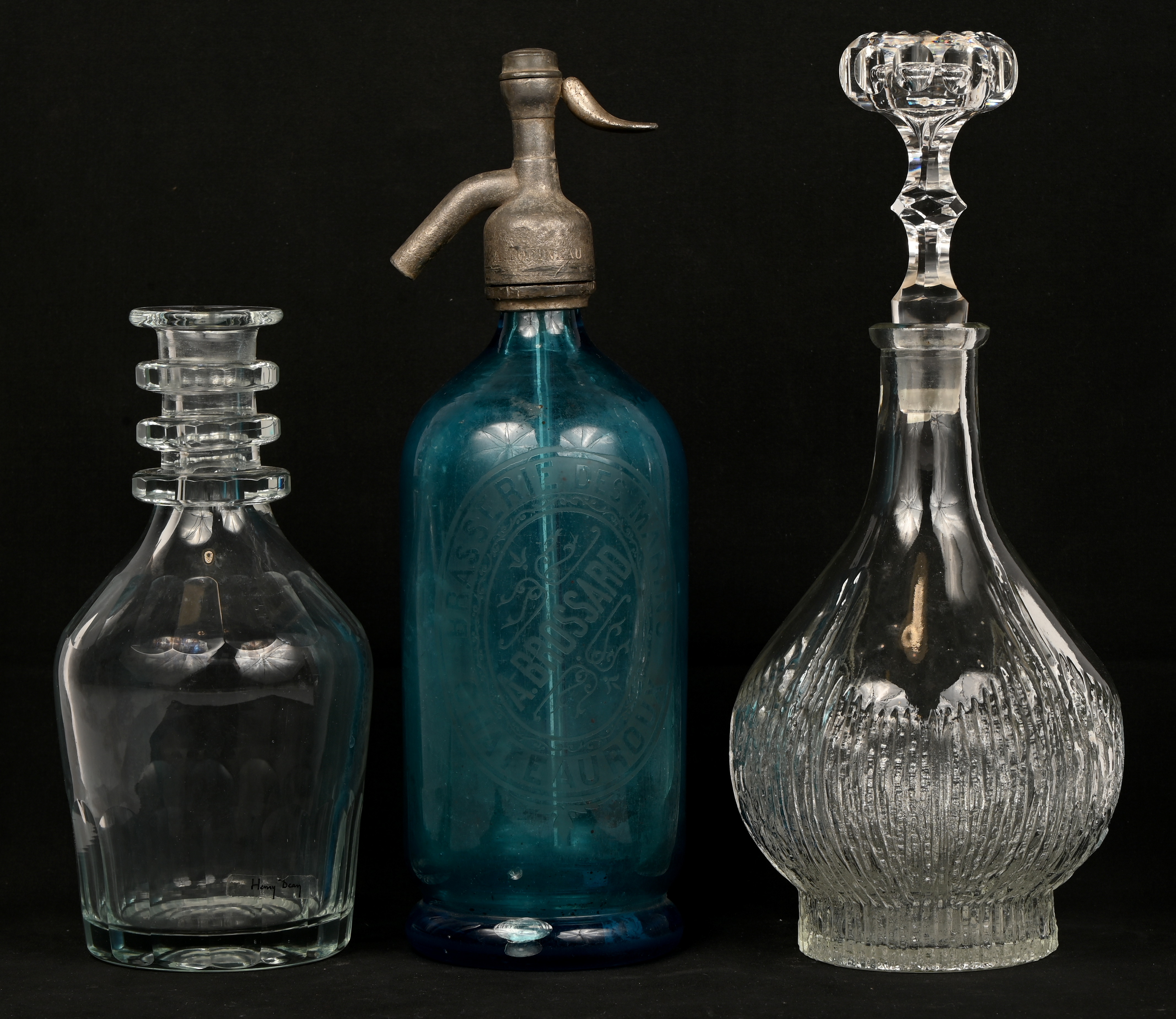 Twee karaffen waarvan één met stop en een sodafles van geëtst blauw glas Twee karaffen waarvan één met stop en een sodafles van geëtst blauw glas.