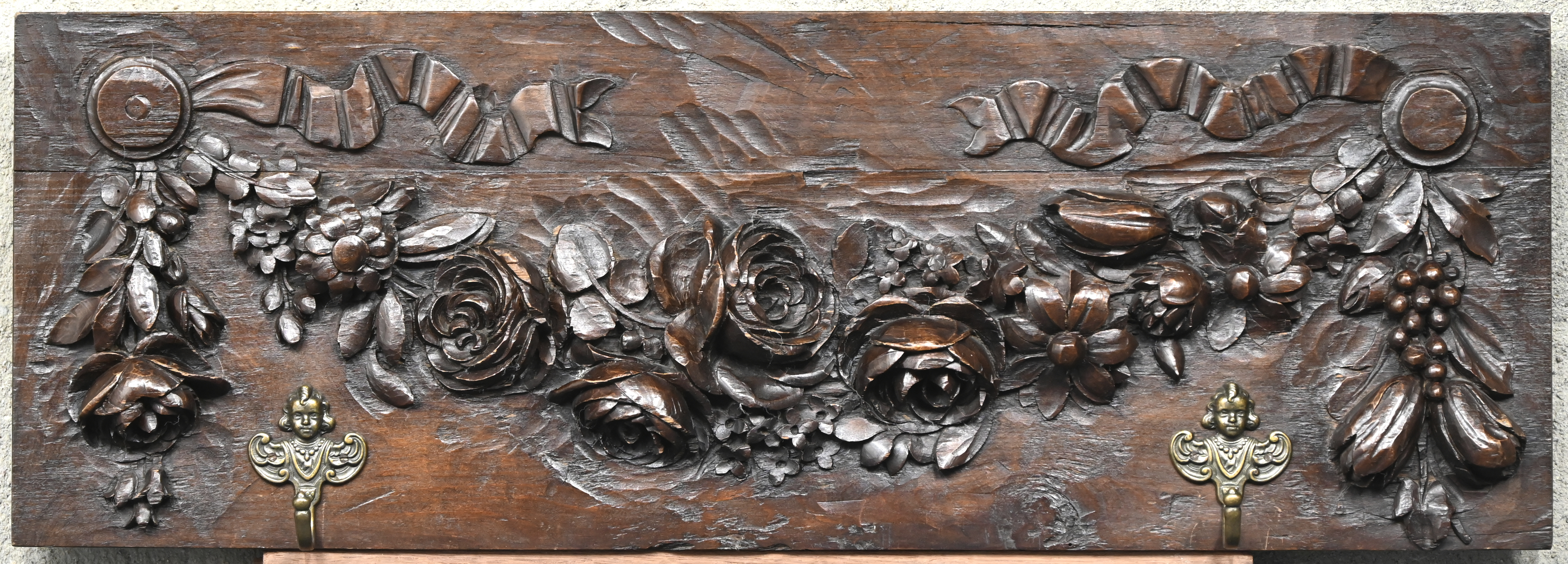 Een houten kapstok met twee haken met fijn gesculpteerd reliëf van rozen Een houten kapstok met twee haken met fijn gesculpteerd reliëf van rozen.