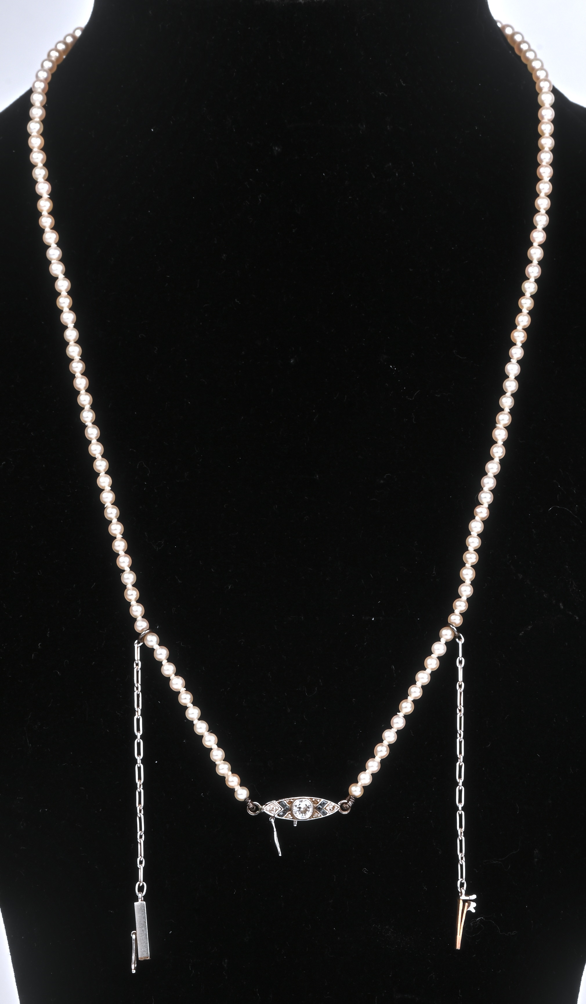 Een fijne parelhalssnoer met 18 kt witgouden slot bezet met diamanten en saffieren met een gezamenlijk gewicht van +- 0,30 ct. en een veiligheidsslot Een fijne parelhalssnoer met 18 kt witgouden slot bezet met diamanten en saffieren met een gezamenlijk gewicht van +- 0,30 ct. en een veiligheidsslot.