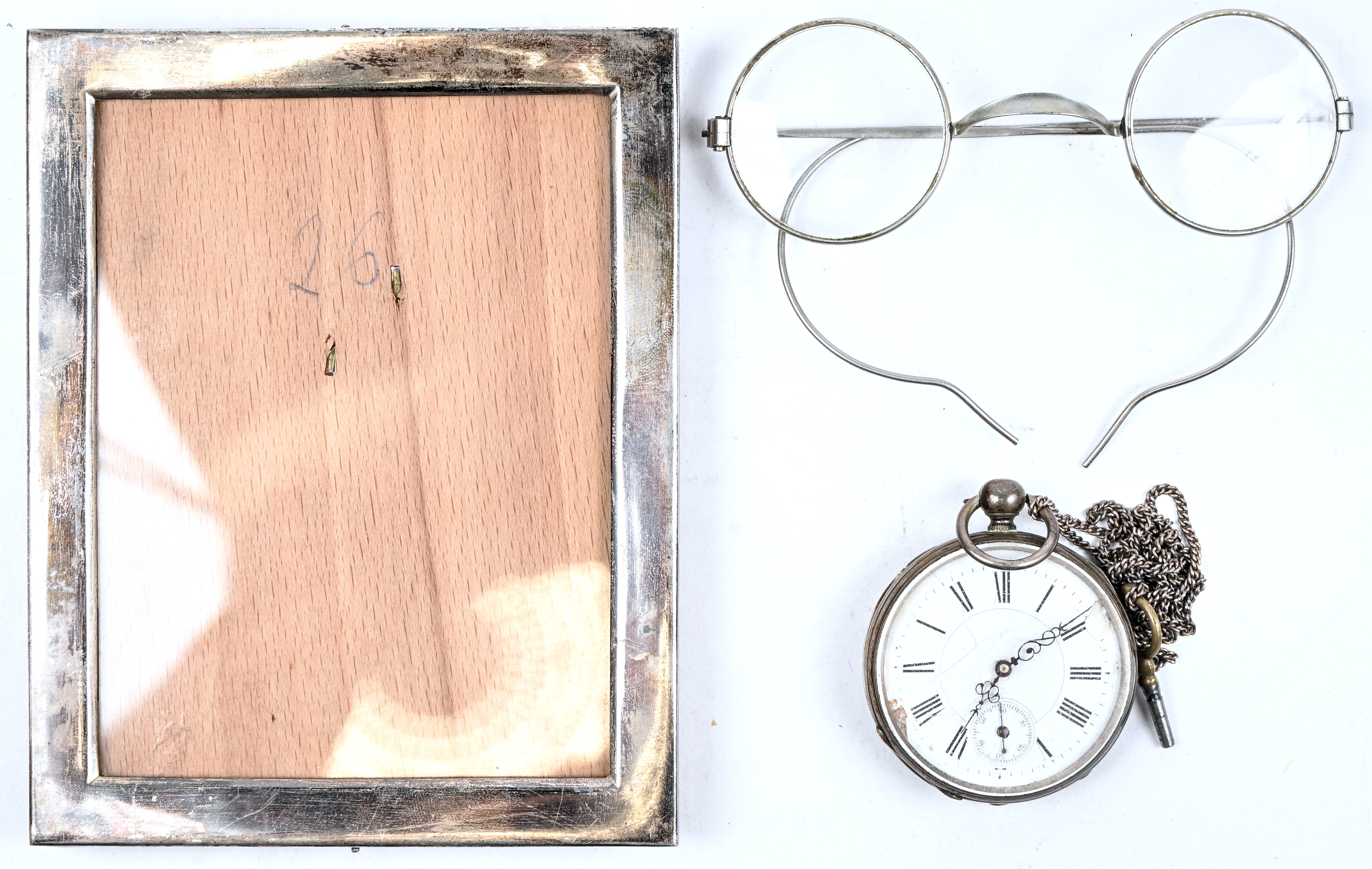 Een gevarieerd lot bestaande uit een zilveren zakhorloge met ketting en sleutel, werkend, beschadigde emaille wijzerplaat, een zilveren fotokadertje gemerkt a 835 en toegevoegd een oud ziekenkasbrilletje Een gevarieerd lot bestaande uit een zilveren zakhorloge met ketting en sleutel, werkend, beschadigde emaille wijzerplaat, een zilveren fotokadertje gemerkt a 835 en toegevoegd een oud ziekenkasbrilletje.