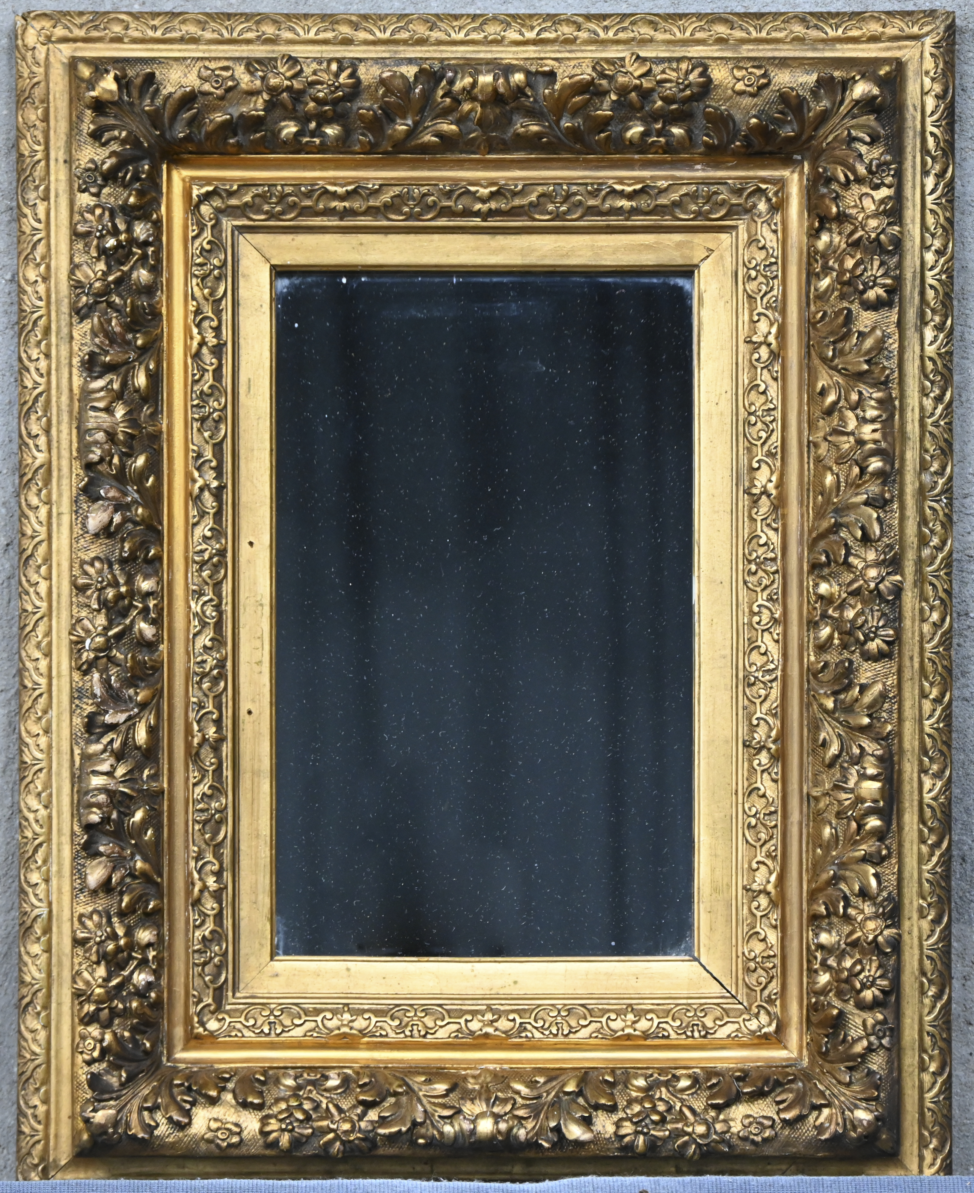 Een rechthoekige spiegel in een goudkleurige kader Een rechthoekige spiegel in een goudkleurige kader.