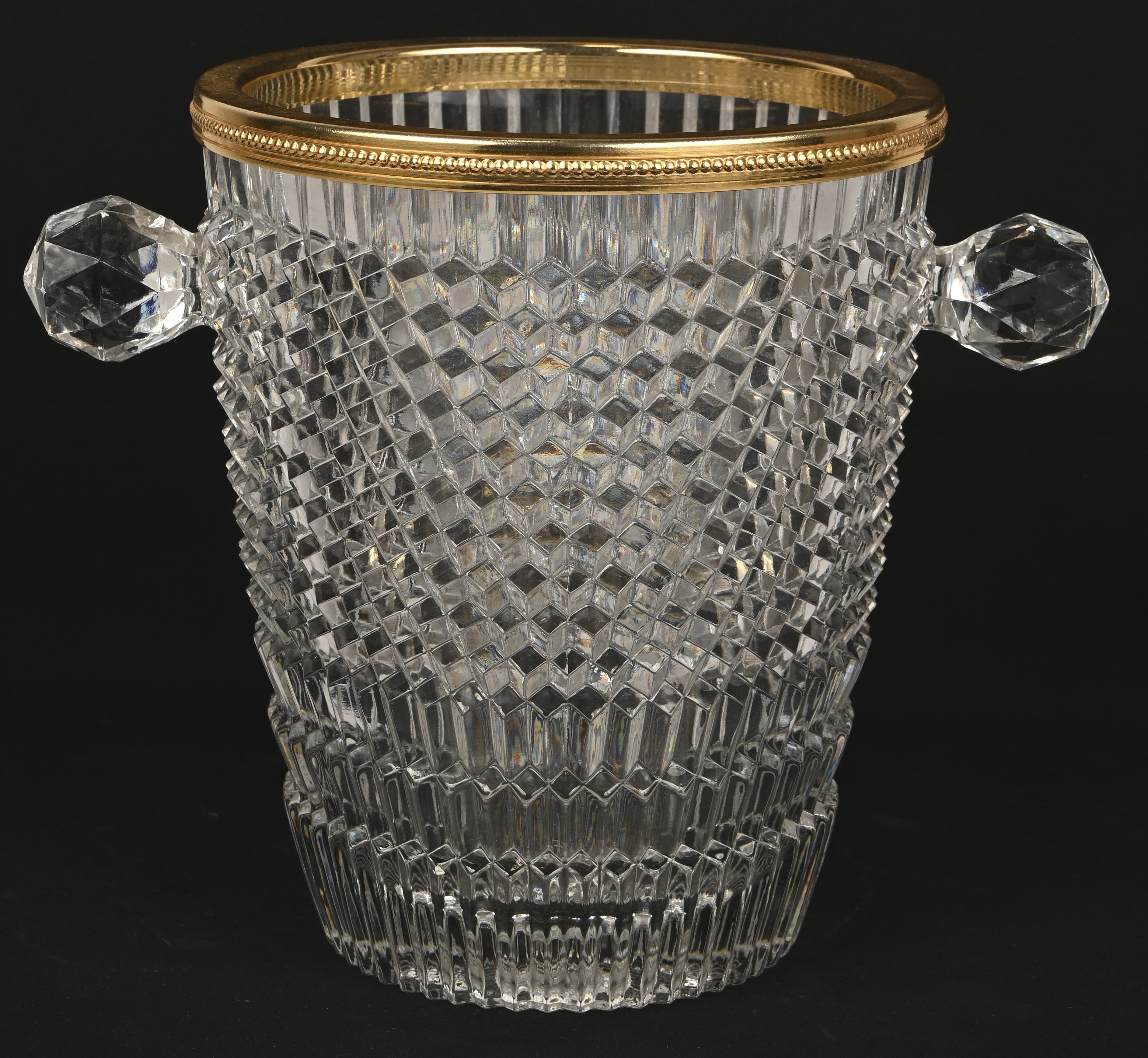 Een champagnekoeler van geperst kristal, met een goudkleurige metalen rand. Niet gemerkt Een champagnekoeler van geperst kristal, met een goudkleurige metalen rand. Niet gemerkt.