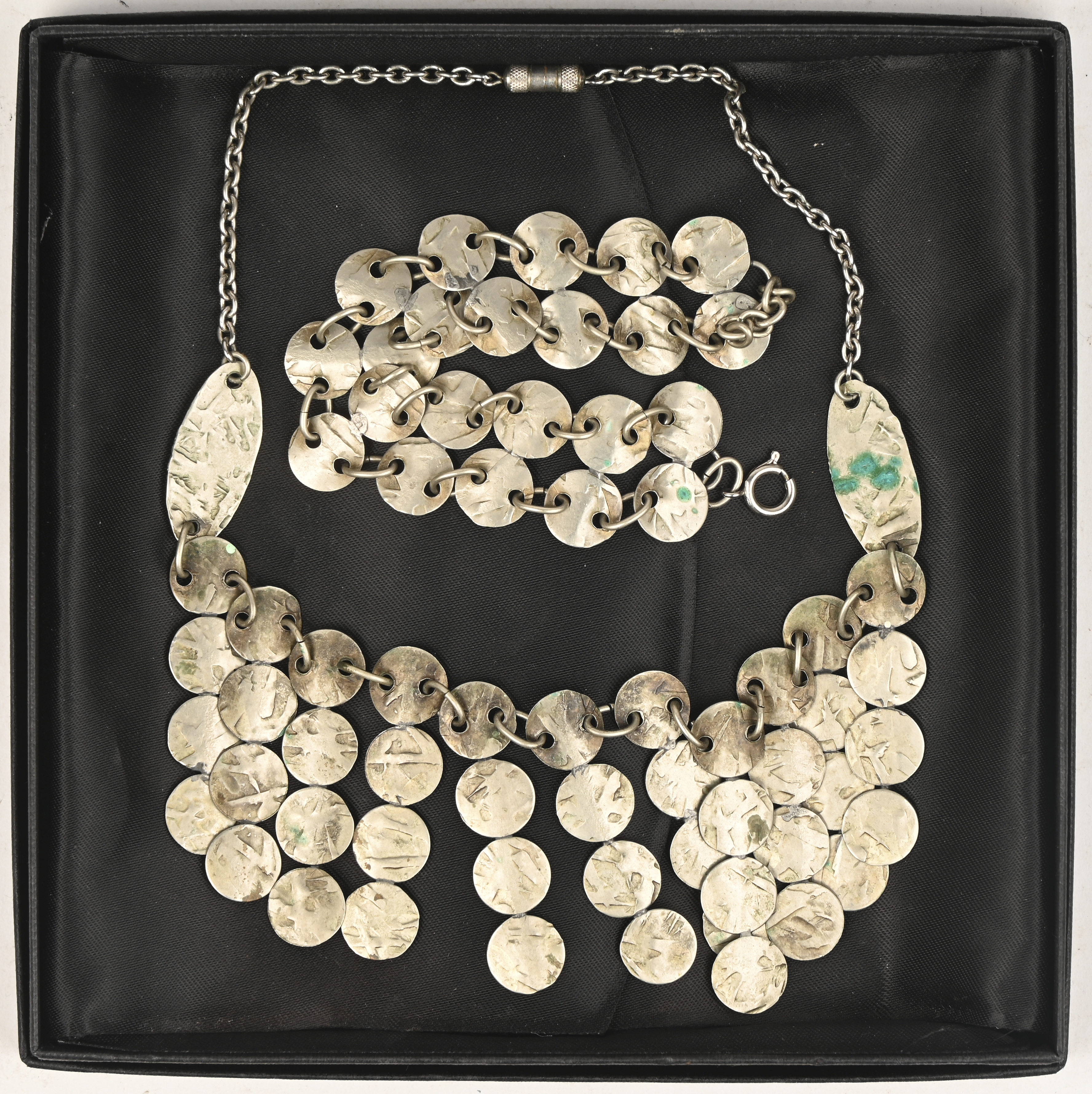 Een vintage setje metalen sierraden, medio jaren 60 van de vorige eeuw, bestaande uit een halsketting en een armband Een vintage setje metalen sierraden, medio jaren 60 van de vorige eeuw, bestaande uit een halsketting en een armband.