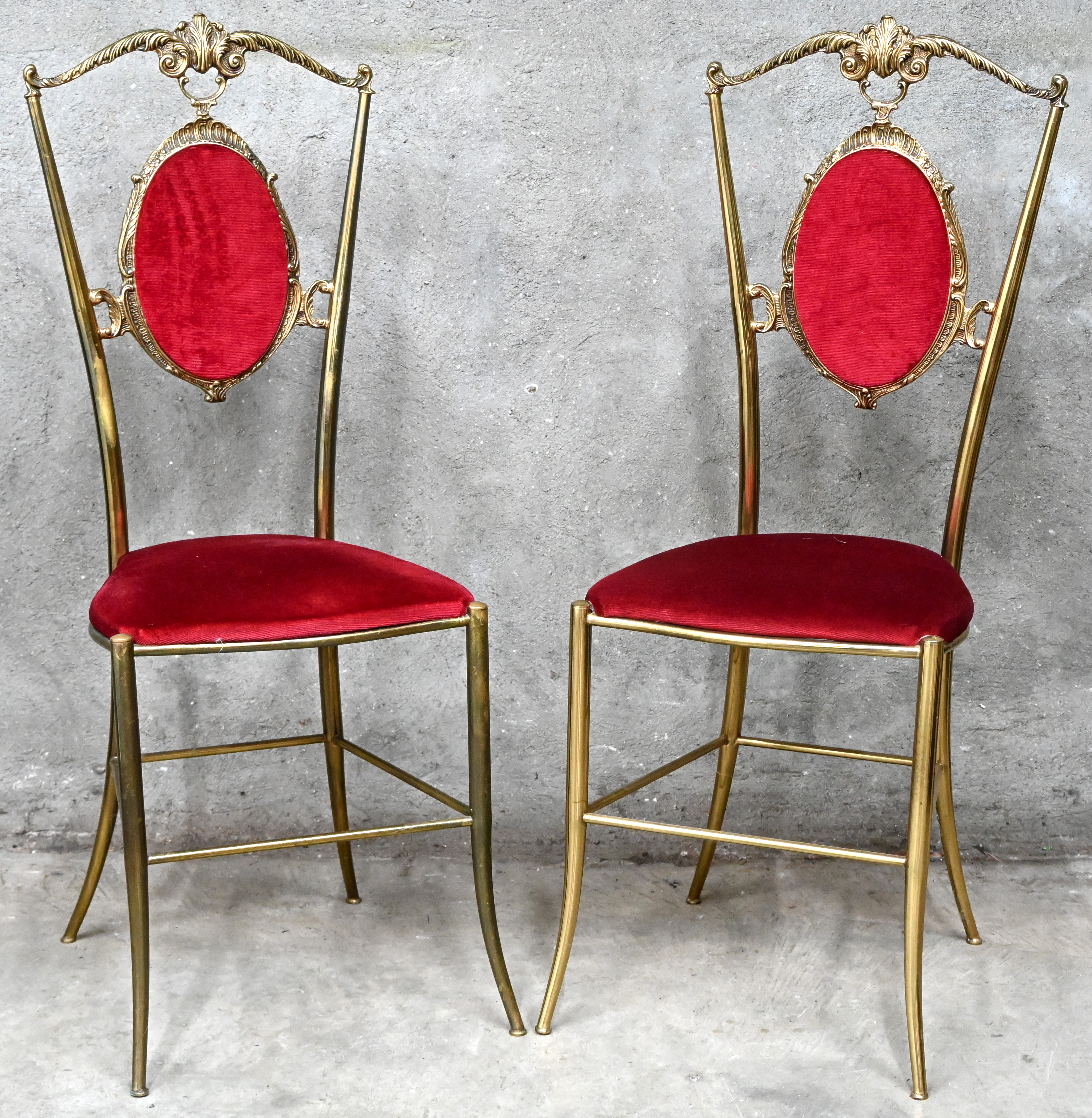 Een paar messingen neo-klassieke stoeltjes met rode fluwelen zit en rug Een paar messingen neo-klassieke stoeltjes met rode fluwelen zit en rug.