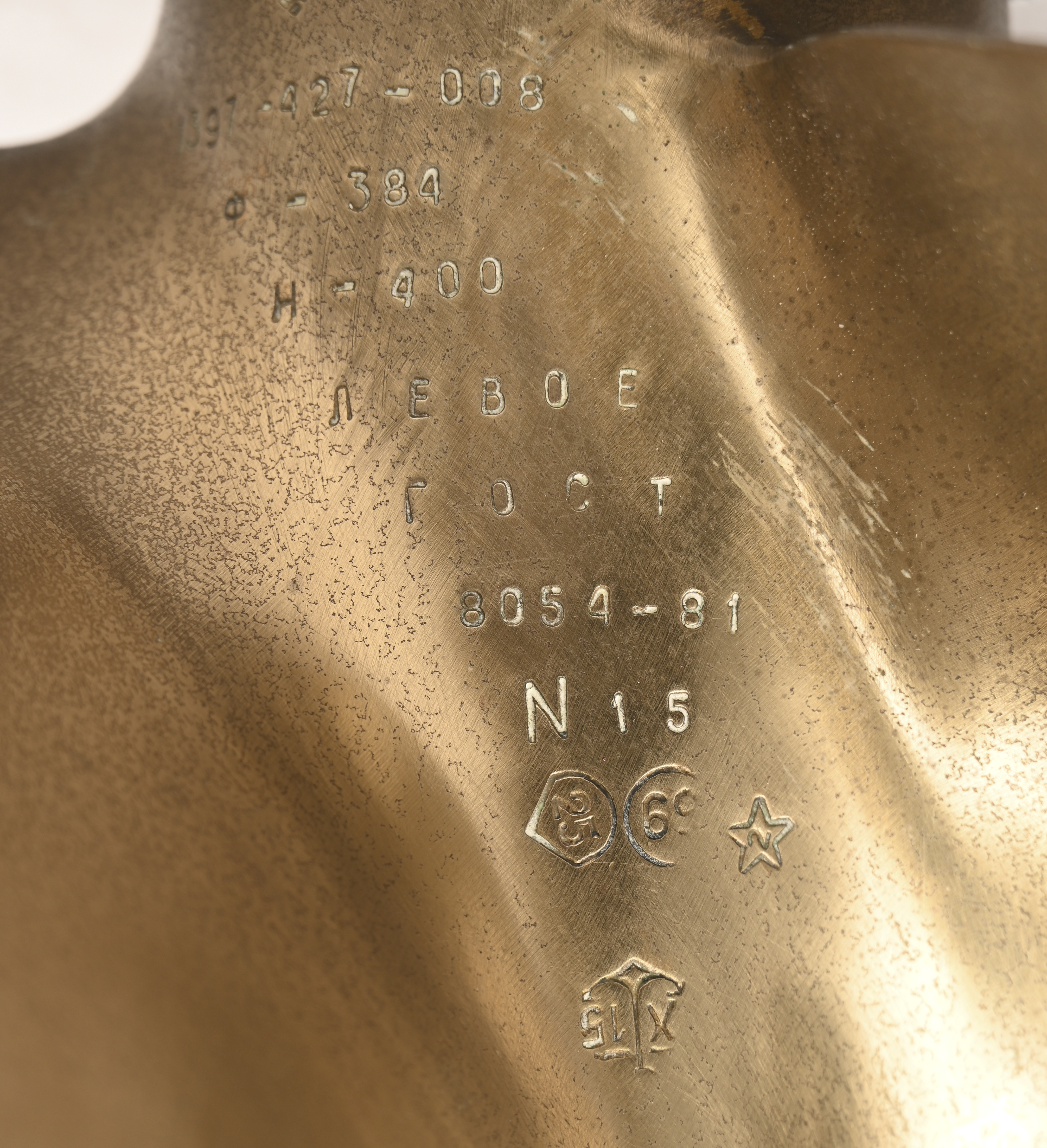 Een koperen schroef van een middelgroot schip met verscheidene nummers en stempels Een koperen schroef van een middelgroot schip met verscheidene nummers en stempels.