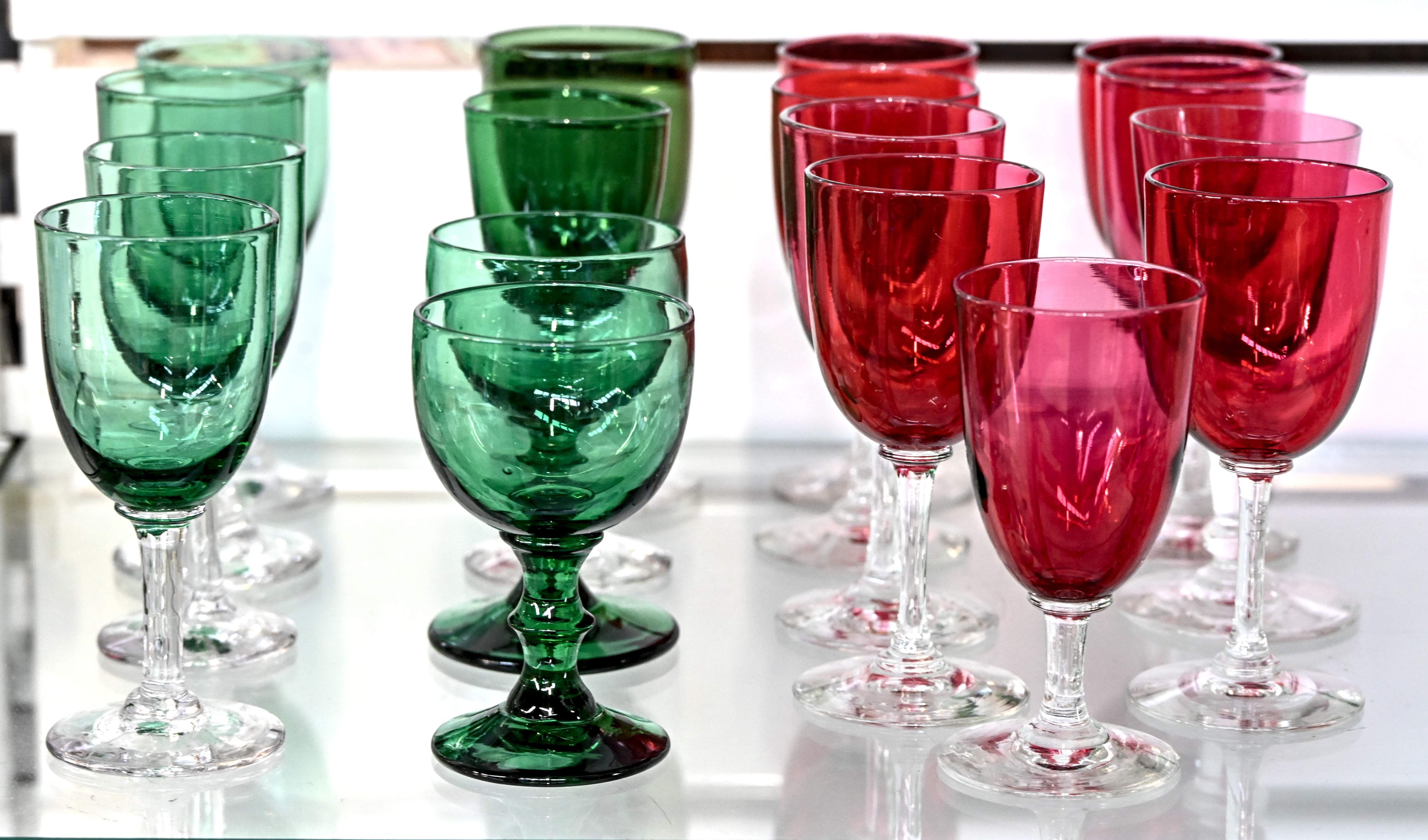 Een set van 17 glazen op voet, mondgeblazen. Acht groene en negen rode, vier verschillende modellen Een set van 17 glazen op voet, mondgeblazen. Acht groene en negen rode, vier verschillende modellen.