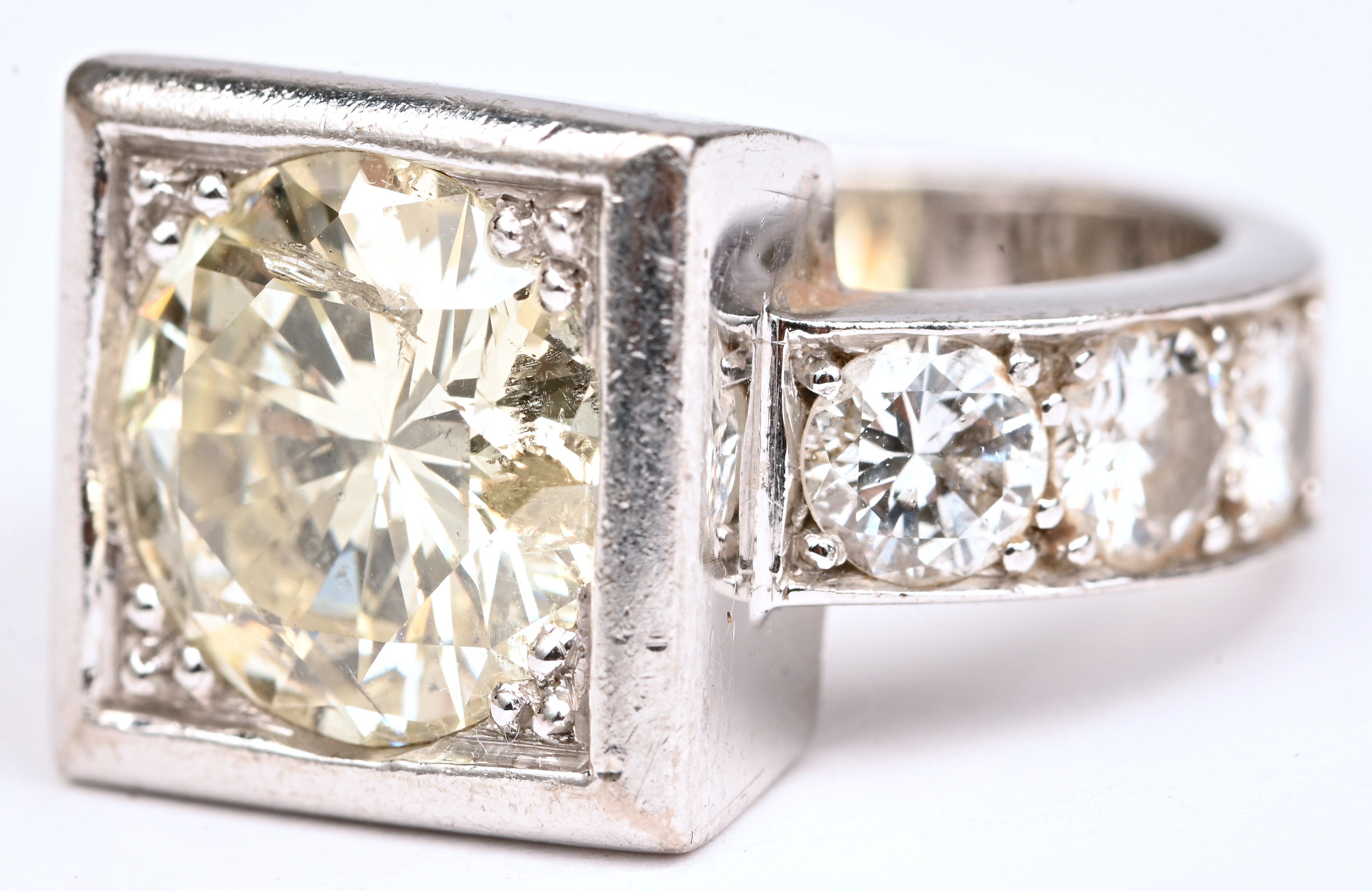 Een platina ring bezet met een centrale diamant van +- 3 ct. en 6 diamanten met een gezamenlijk gewicht van +- 1,20 ct Een platina ring bezet met een centrale diamant van +- 3 ct. en 6 diamanten met een gezamenlijk gewicht van +- 1,20 ct.