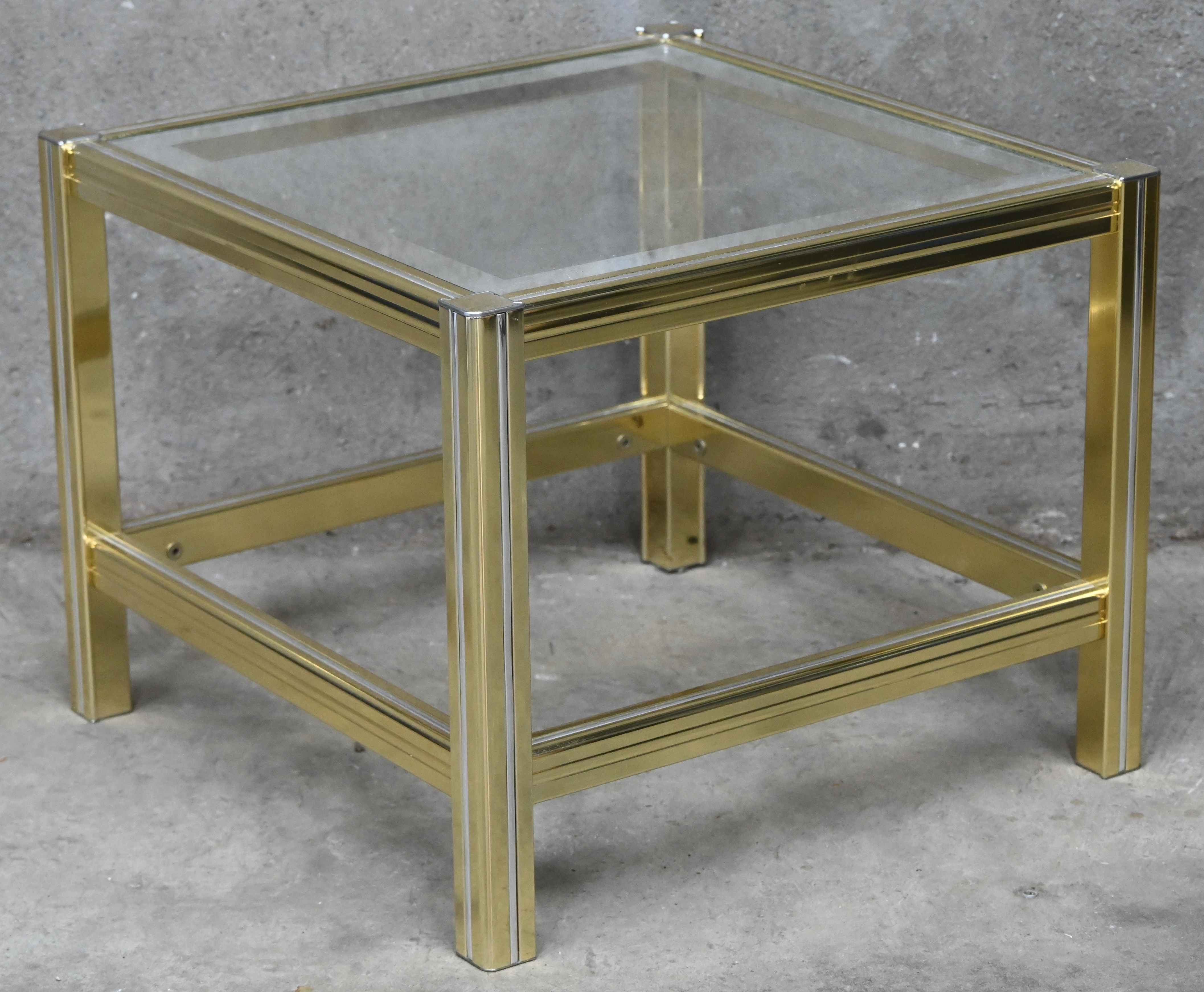 Een vintage salontafeltje van goudkleurig aluminium en glas. In de stijl van Pierre Vandel Een vintage salontafeltje van goudkleurig aluminium en glas. In de stijl van Pierre Vandel.