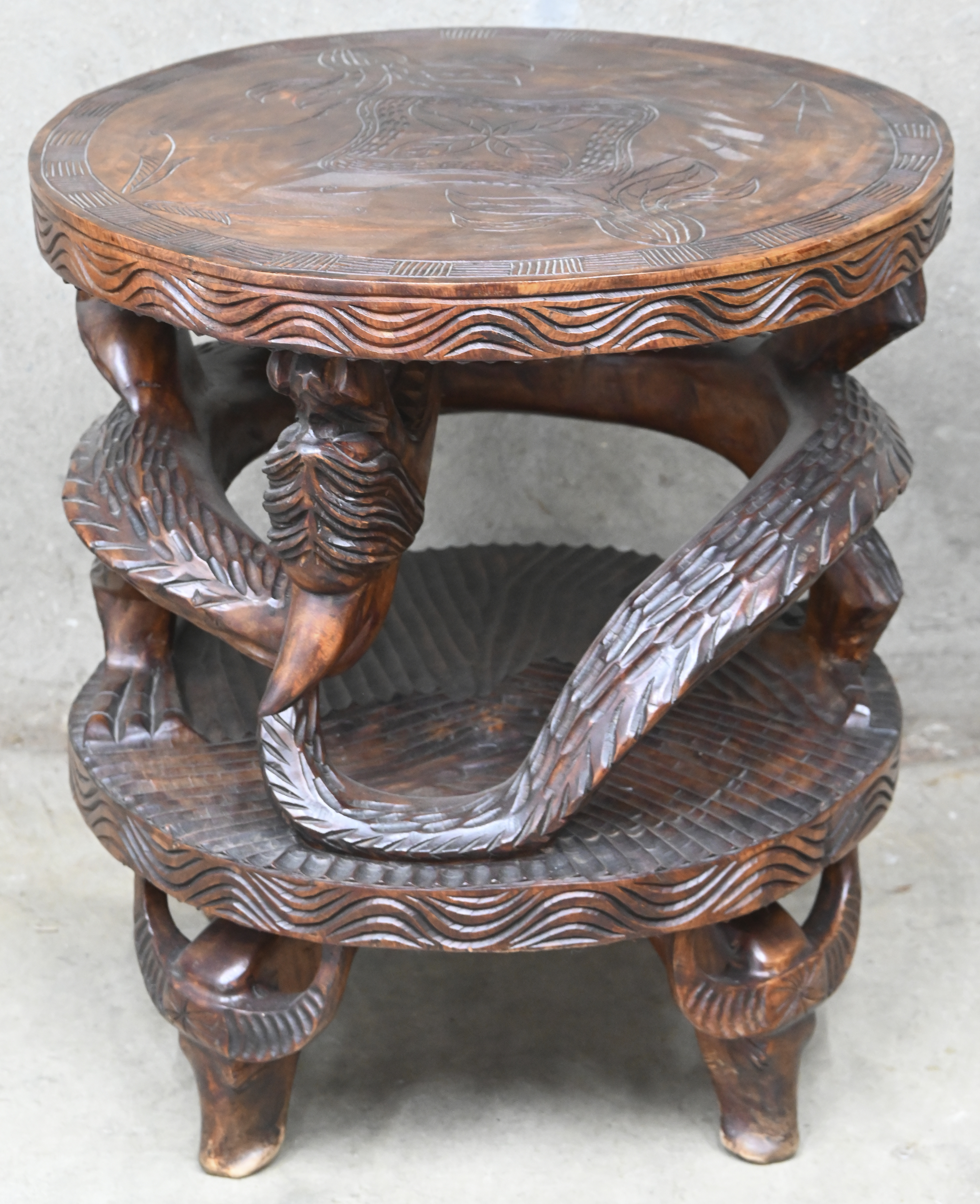 Een gesculpteerd Aziatisch bijzettafeltje met fabeldieren en gedragen door buffelkoppen Een gesculpteerd Aziatisch bijzettafeltje met fabeldieren en gedragen door buffelkoppen.