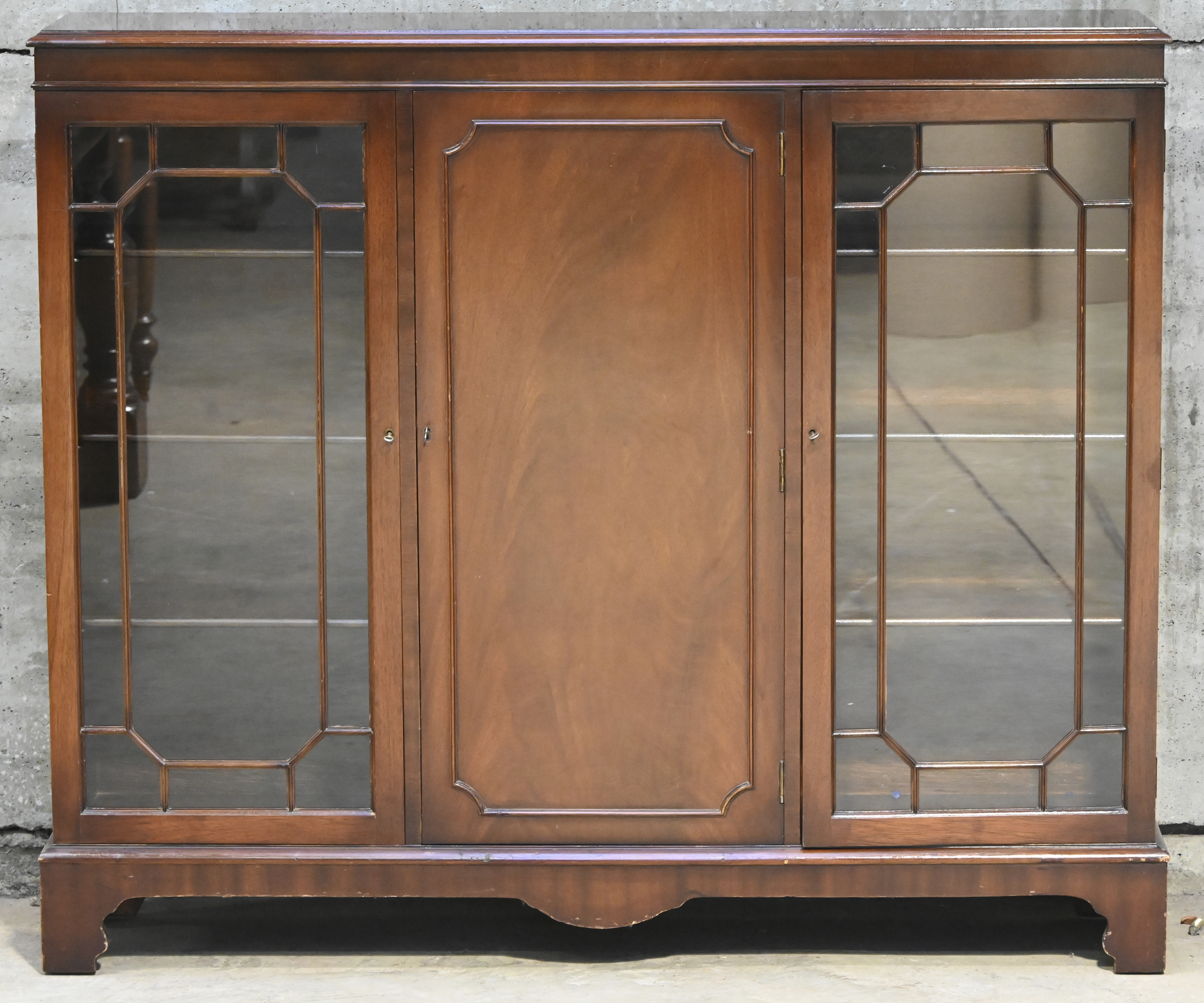 Een lage vitrinekast in Engelse stijl. Drie deuren Een lage vitrinekast in Engelse stijl. Drie deuren.