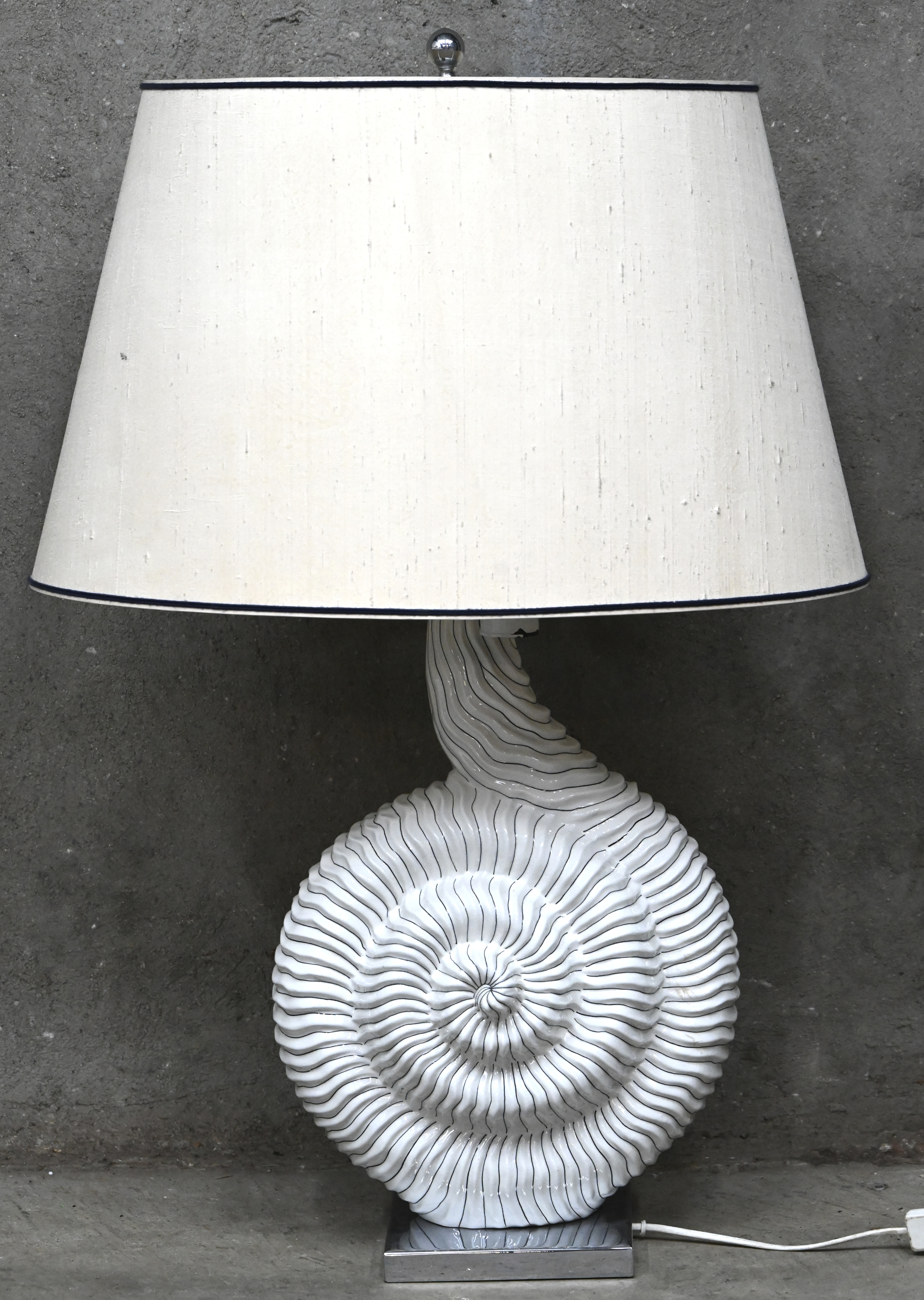 Een grote keramische tafellamp in de stijl van Mangani Firenze, gevormd als een amoniet. Met herstellingswerk aan de fittingen Een grote keramische tafellamp in de stijl van Mangani Firenze, gevormd als een amoniet. Met herstellingswerk aan de fittingen.