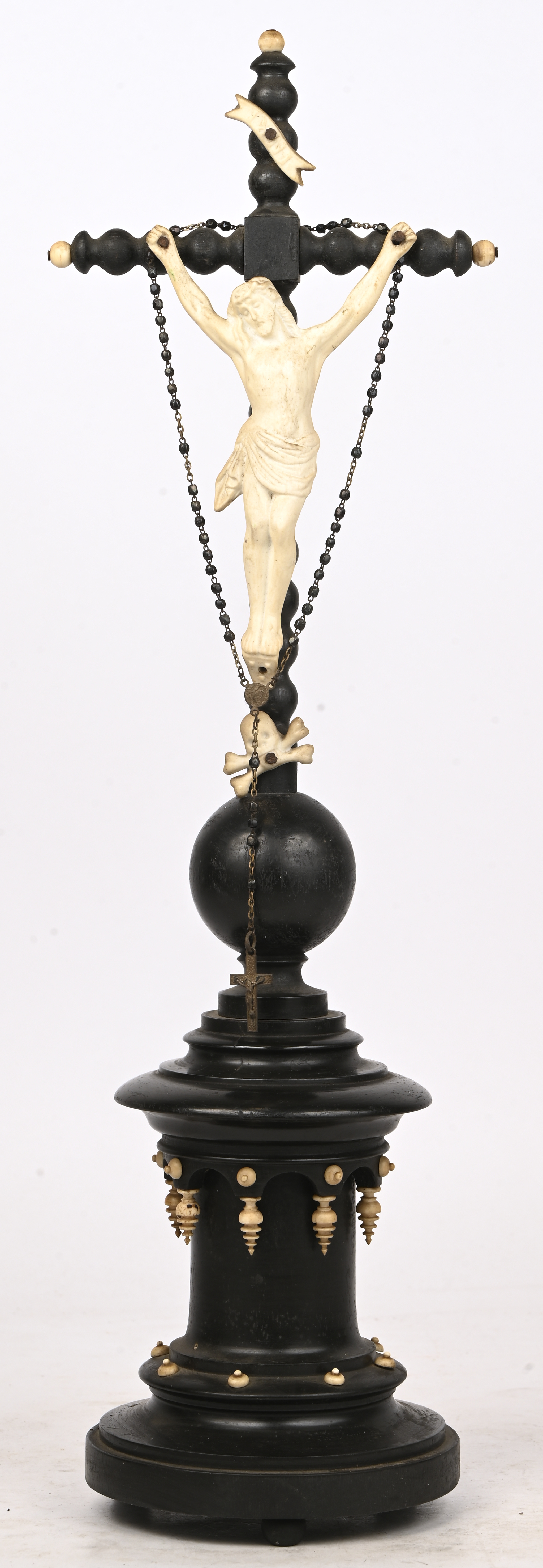 Een antiek kruisbeeld van geëboniseerd hout en porselein Een antiek kruisbeeld van geëboniseerd hout en porselein.