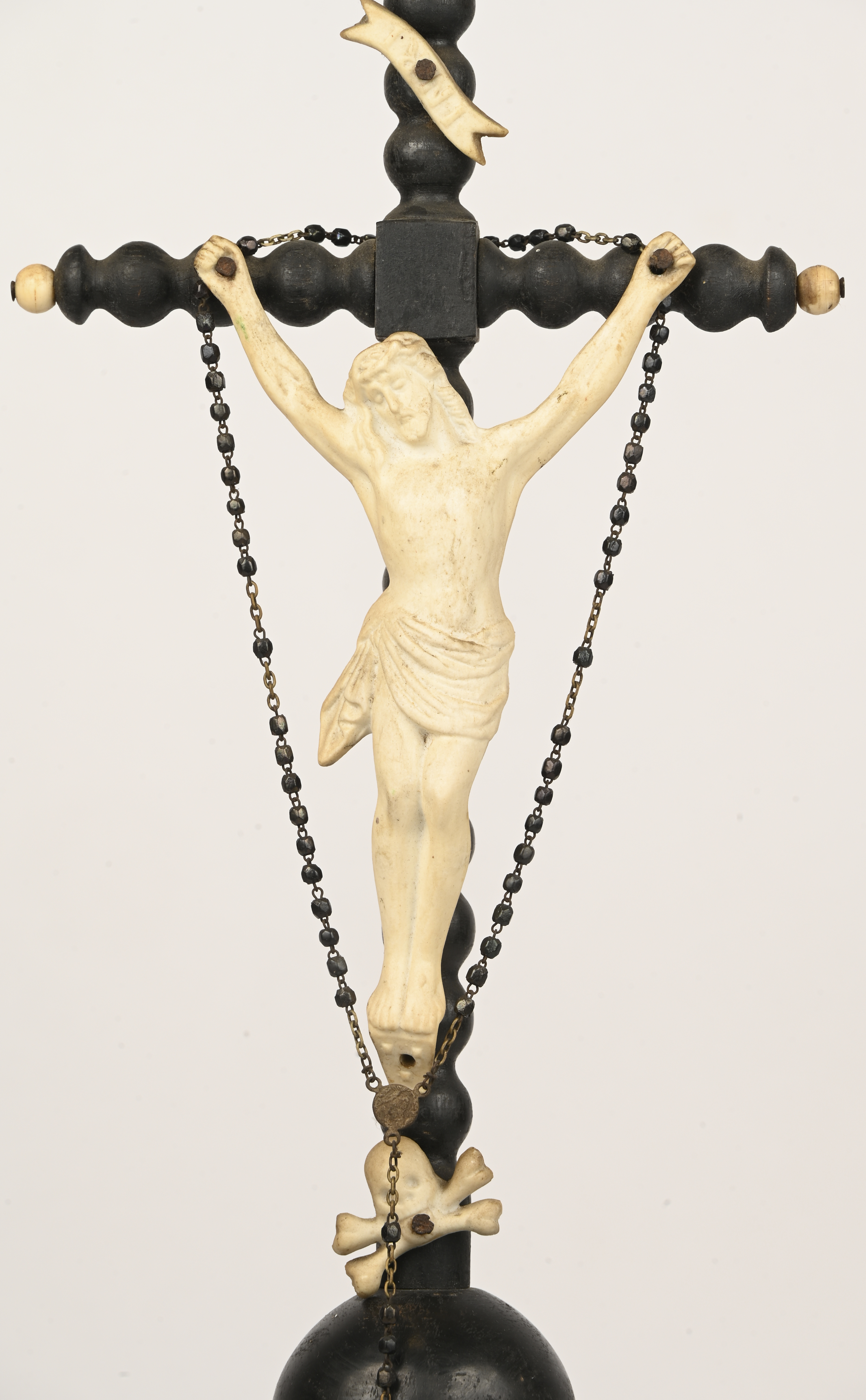 Een antiek kruisbeeld van geëboniseerd hout en porselein Een antiek kruisbeeld van geëboniseerd hout en porselein.