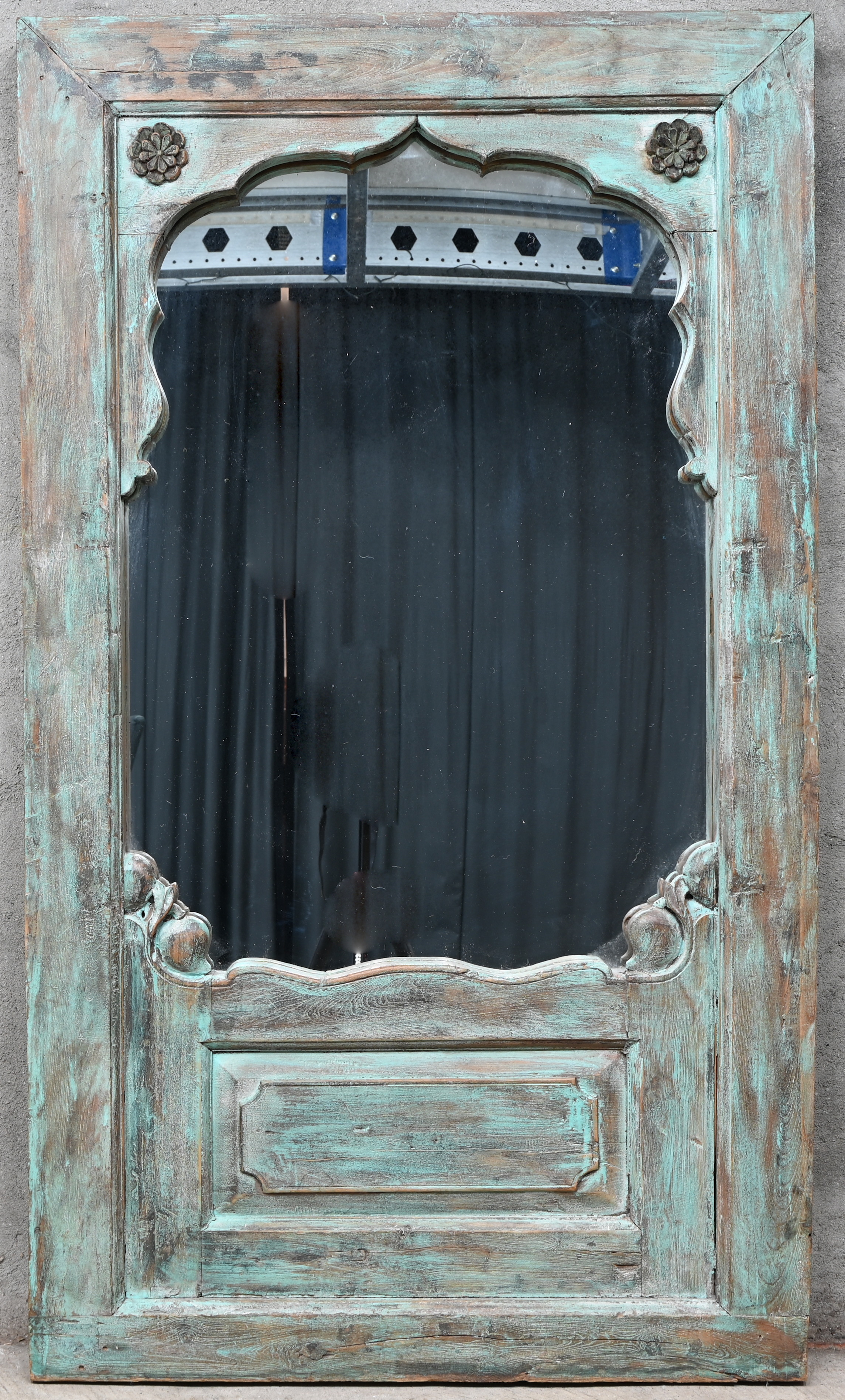 Een spiegel ingewerkt in een massief houten Indisch deurpaneel met groenblauwe polychromie Een spiegel ingewerkt in een massief houten Indisch deurpaneel met groenblauwe polychromie.