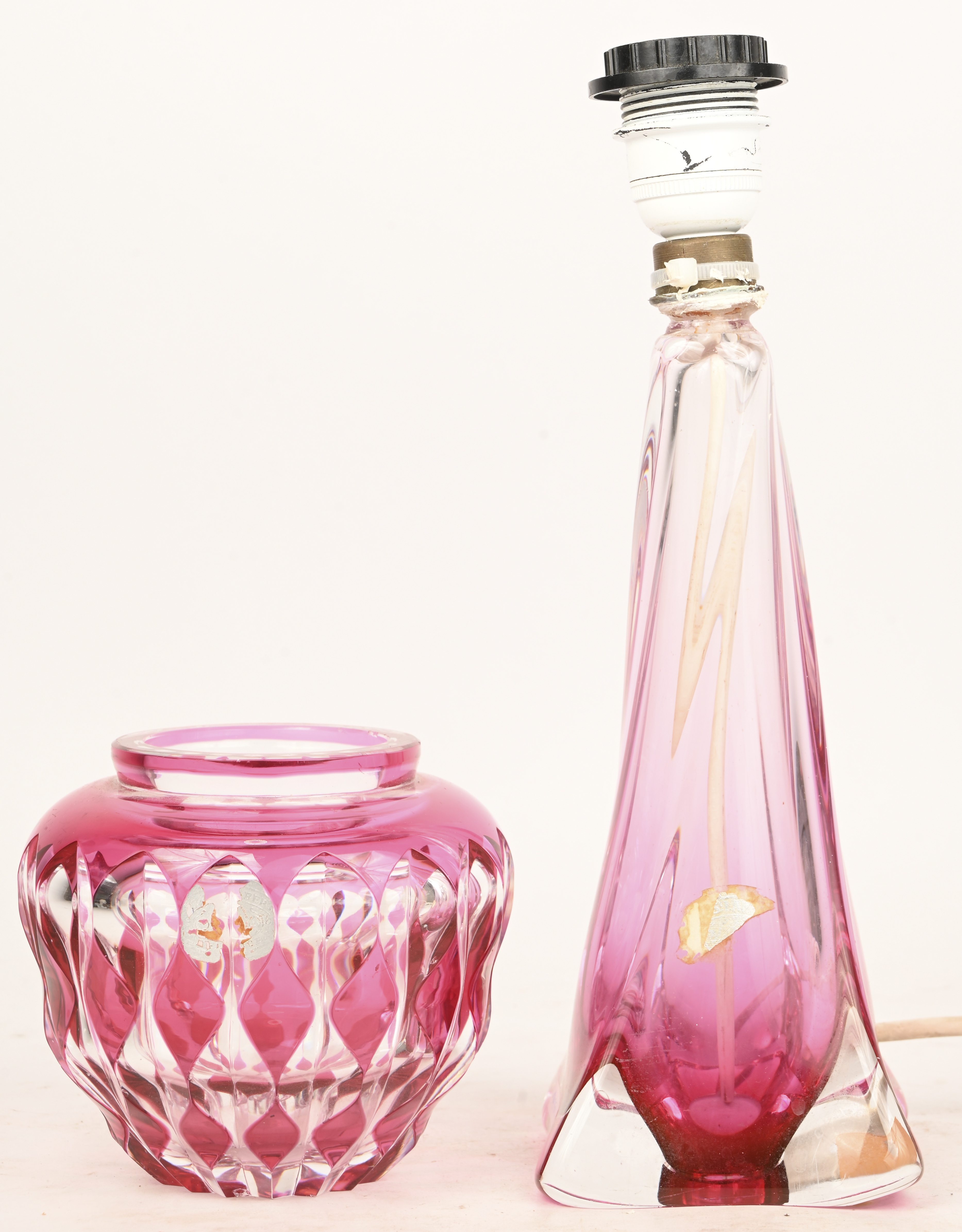 Een lot bestaande uit resp. geslepen en gegoten kristal, rood in te massa, een vaasje en lampenvoet Een lot bestaande uit resp. geslepen en gegoten kristal, rood in te massa, een vaasje en lampenvoet.