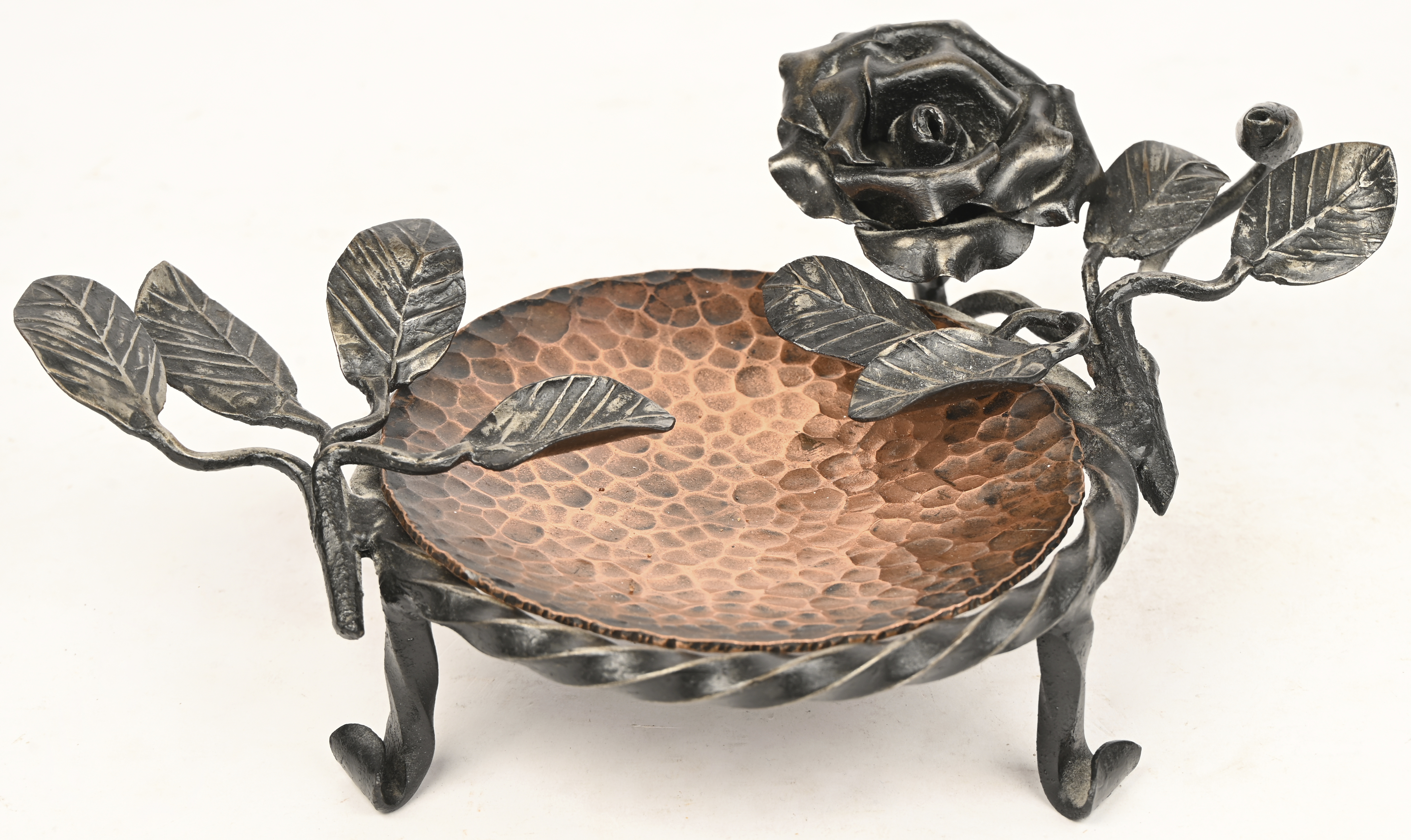 Een smeedijzeren asbak met gehamerd koperen schaaltje Een smeedijzeren asbak met gehamerd koperen schaaltje.