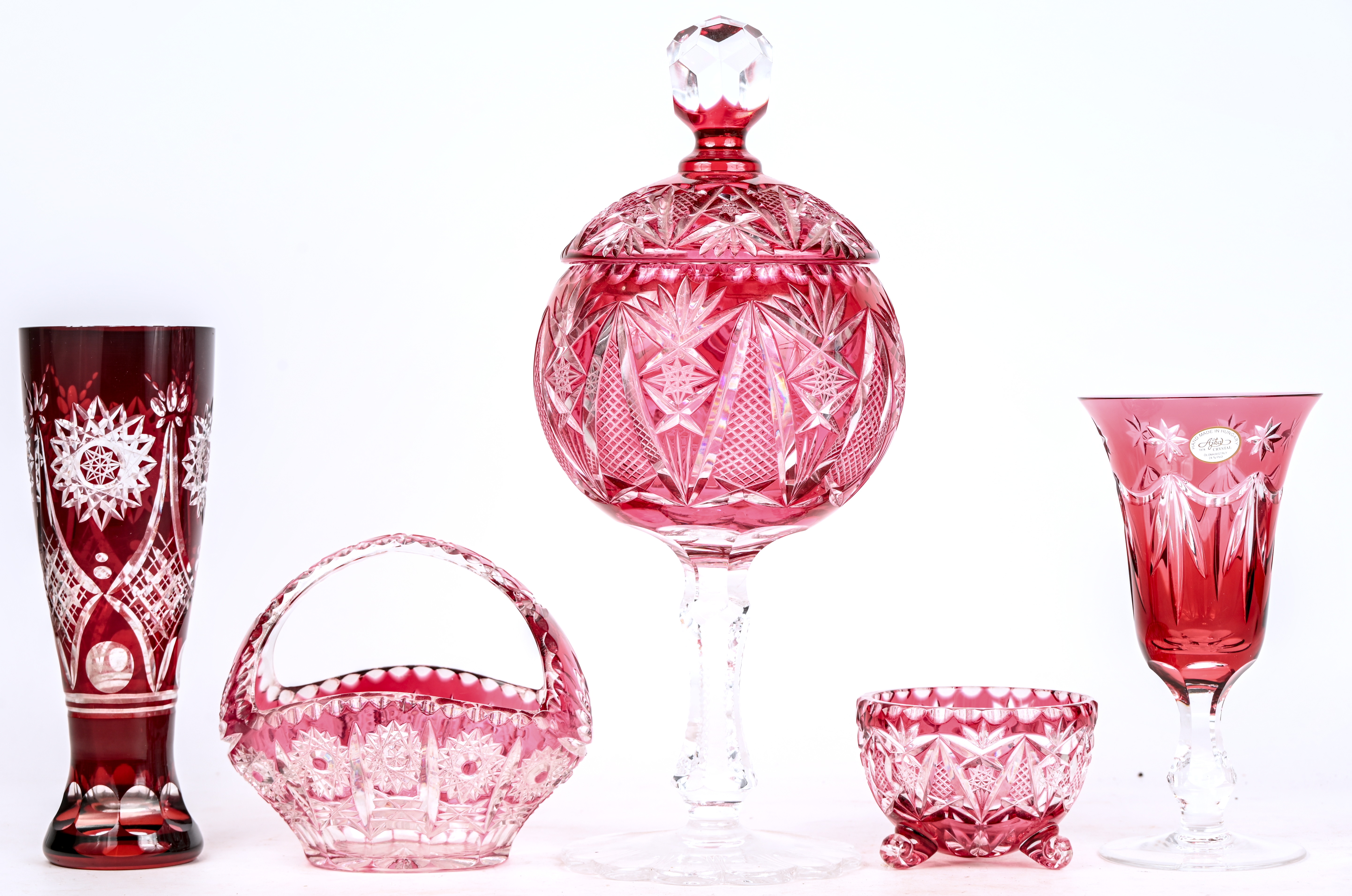 Een gevarieerd lot van 5 kristallen items, rood in de massa gekleurd, bestaande uit een mandje, een kom, twee vazen een een coupe met deksel op voet 1 Een gevarieerd lot van 5 kristallen items, rood in de massa gekleurd, bestaande uit een mandje, een kom, twee vazen een een coupe met deksel op voet