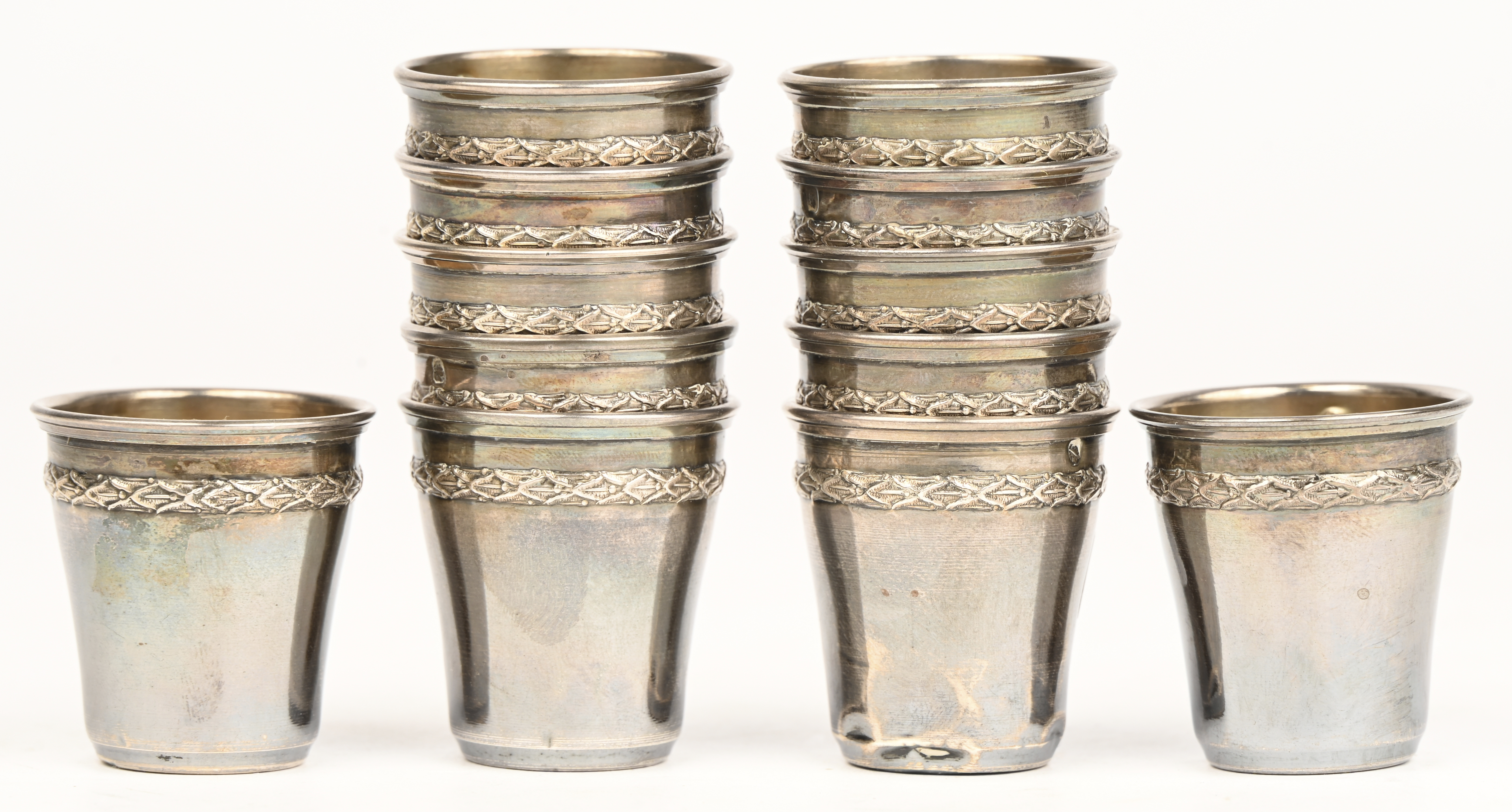 Een set van 12 zilveren shotglaasjes, Frans gekeurd: Minerva en hoofdletters LN met een boompje tussen de letters. 85 gram. Gedeukt Een set van 12 zilveren shotglaasjes, Frans gekeurd: Minerva en hoofdletters LN met een boompje tussen de letters. 85 gram. Gedeukt.