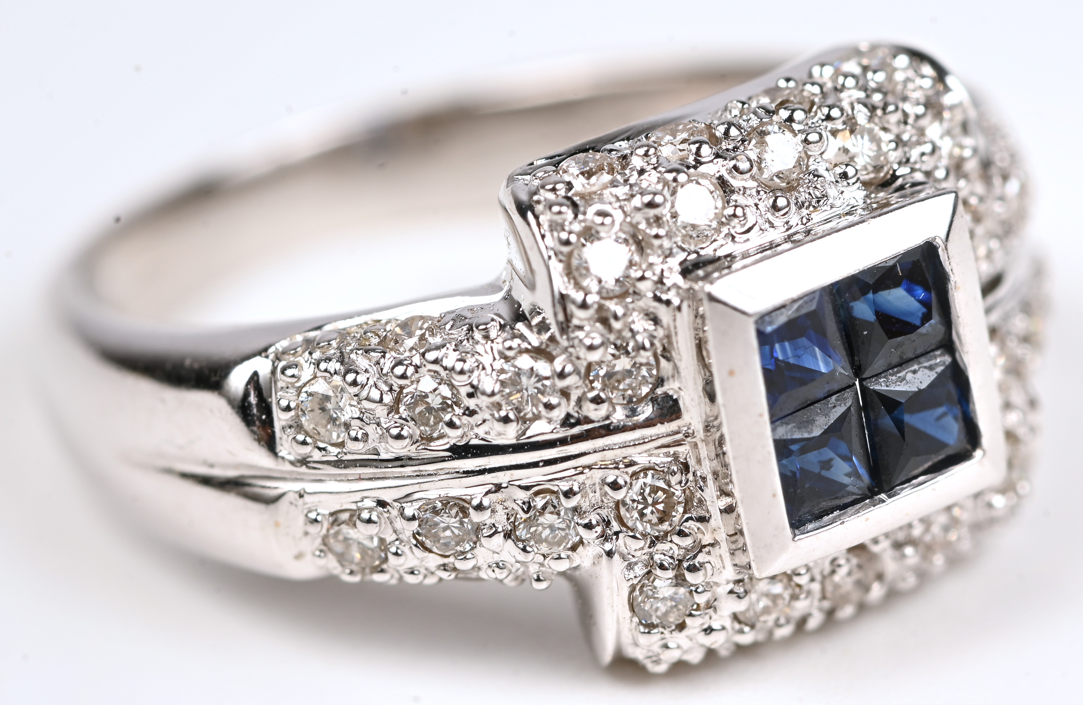 Een 18 kt witgouden ring bezet met 4 saffieren met een gezamenlijk gewicht van 0,52 ct en met briljanten van een gezamenlijk gewicht van 1,16 ct Een 18 kt witgouden ring bezet met 4 saffieren met een gezamenlijk gewicht van 0,52 ct en met briljanten van een gezamenlijk gewicht van 1,16 ct.