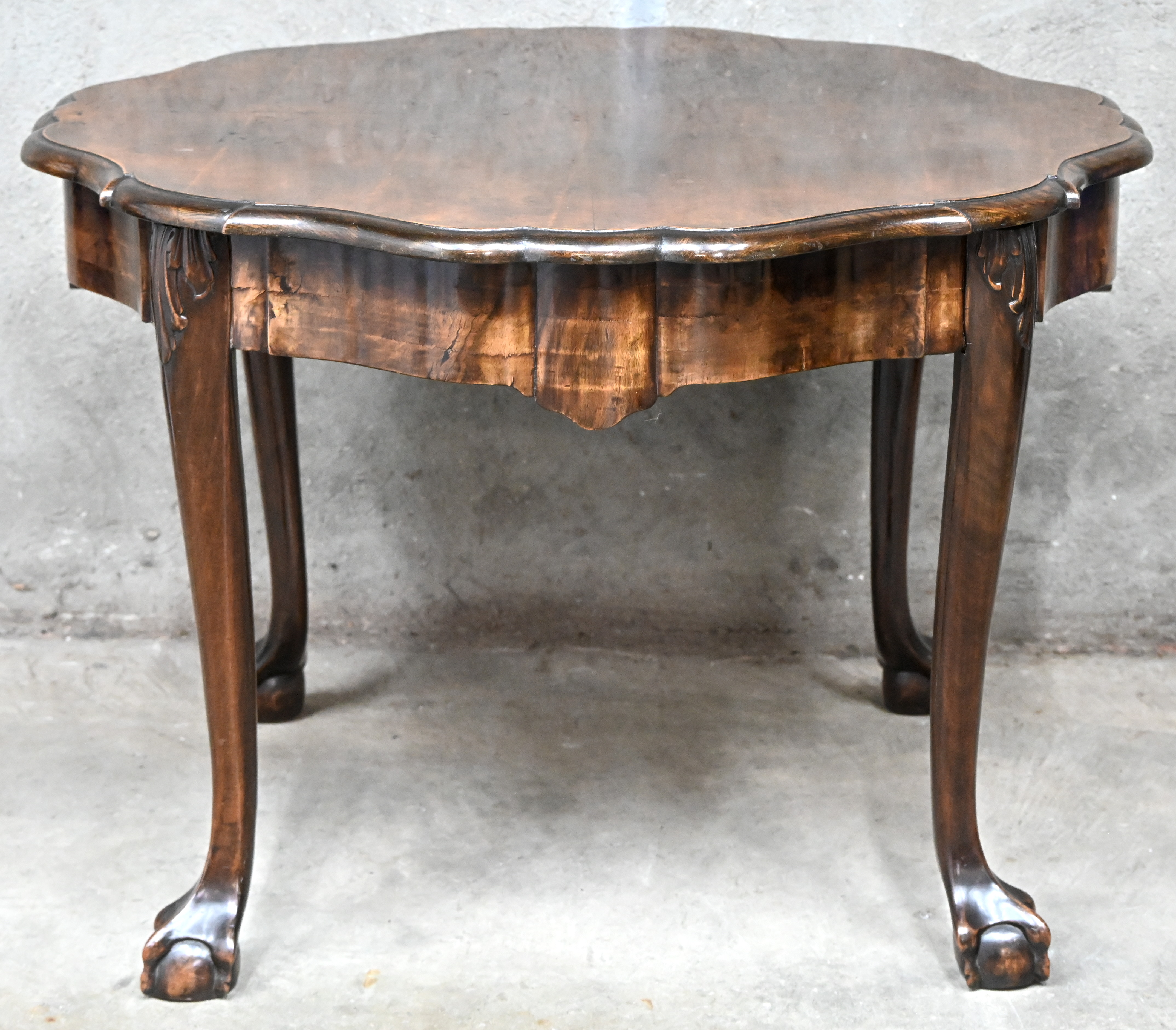 Een ronde houten salontafel met klauwpoten Een ronde houten salontafel met klauwpoten.