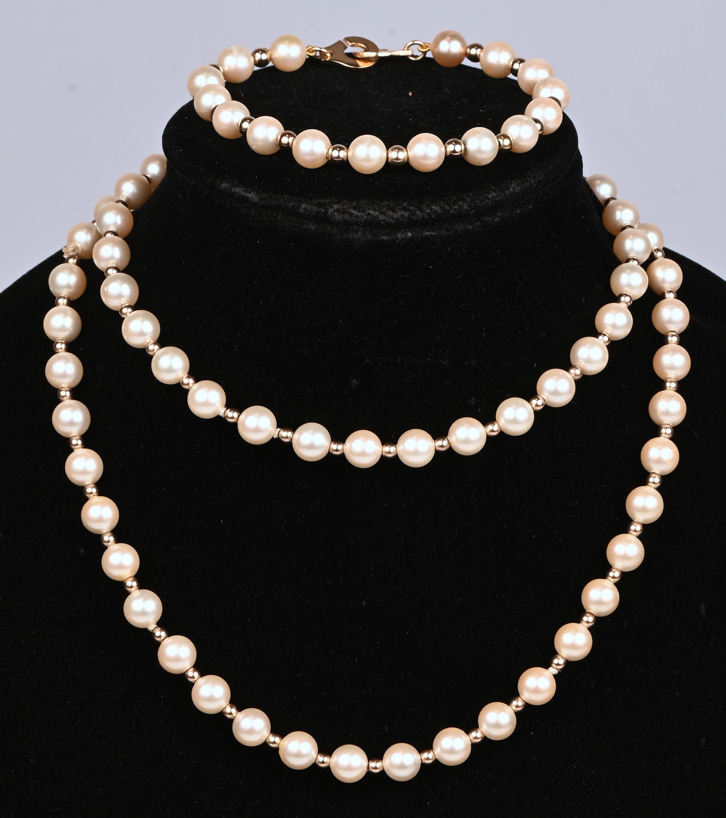 Een halssnoer met bijpassende armband bezet met parels en 18 kt geelgouden bolletjes en slot Een halssnoer met bijpassende armband bezet met parels en 18 kt geelgouden bolletjes en slot.