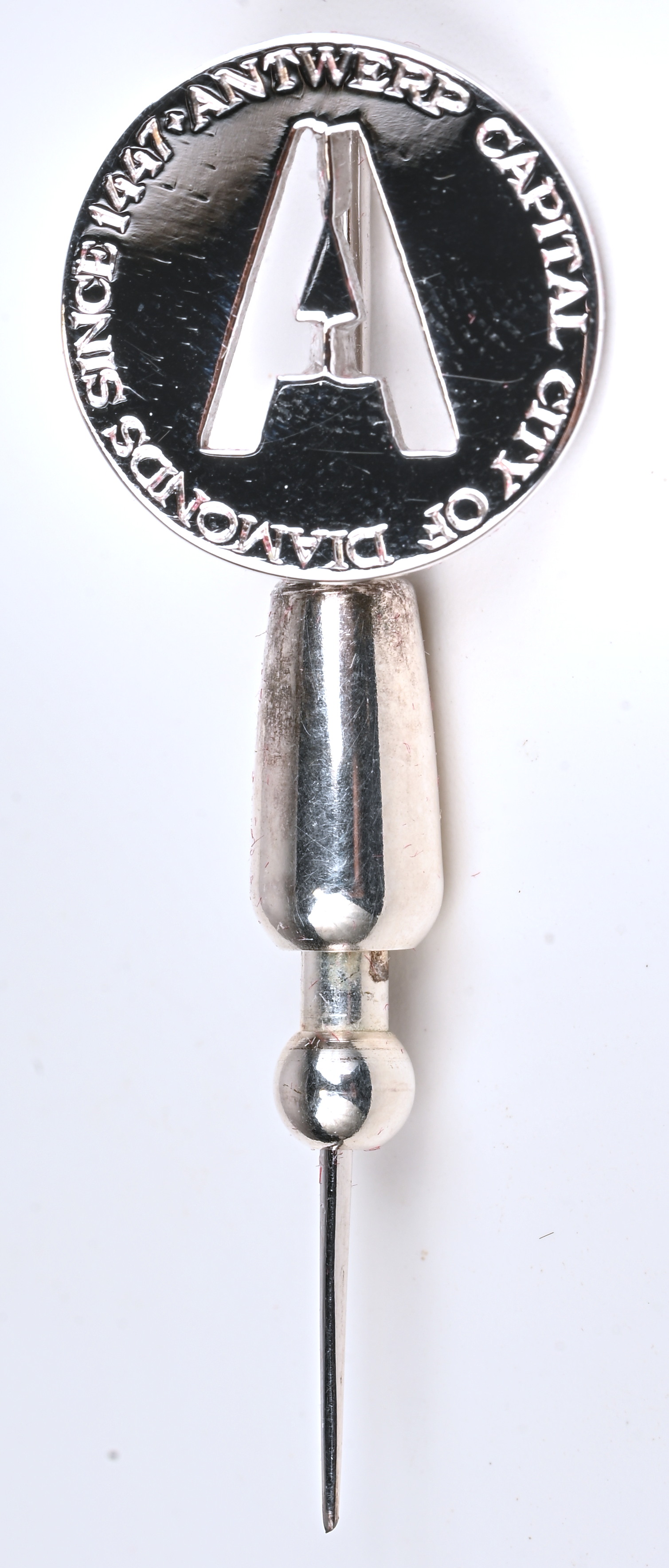 Een 18 kt witgouden speld. Uniek ontwerp met gravure 570 jaar diamant Antwerpen Een 18 kt witgouden speld. Uniek ontwerp met gravure 570 jaar diamant Antwerpen.