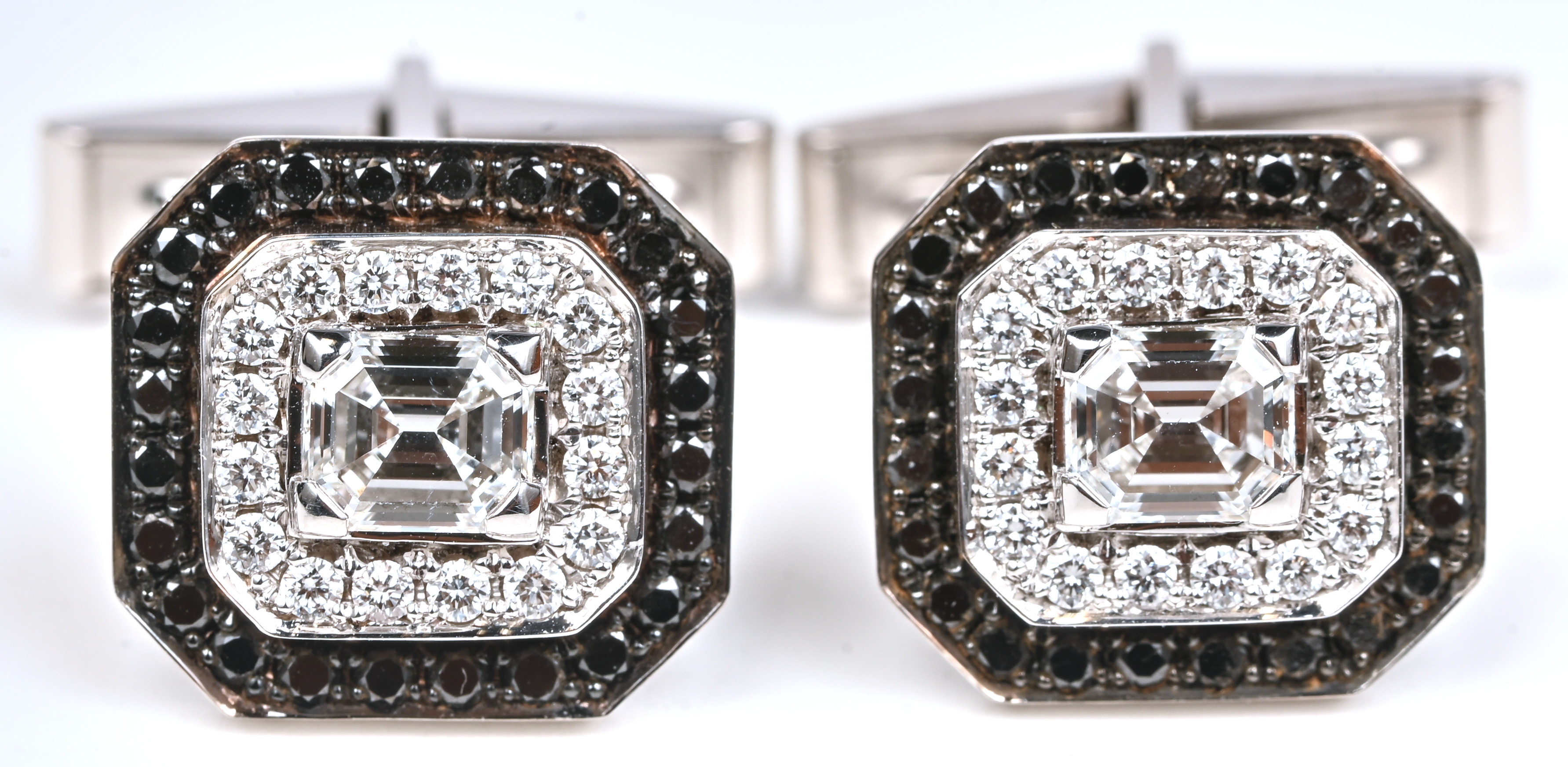 Een paar 18 kt witgouden manchetknopen bezet met twee diamenten emerald cut met een gezamenlijk gewicht van +- 1,13 ct. Witte diamanten met een gezamenlijk gewicht van +- 0,36 ct. F/VVS en zwarte diamenten met een gezamenlijk gewicht van +- 0,60 ct Een paar 18 kt witgouden manchetknopen bezet met twee diamenten emerald cut met een gezamenlijk gewicht van +- 1,13 ct. Witte diamanten met een gezamenlijk gewicht van +- 0,36 ct. F/VVS en zwarte diamenten met een gezamenlijk gewicht van +- 0,60 ct.