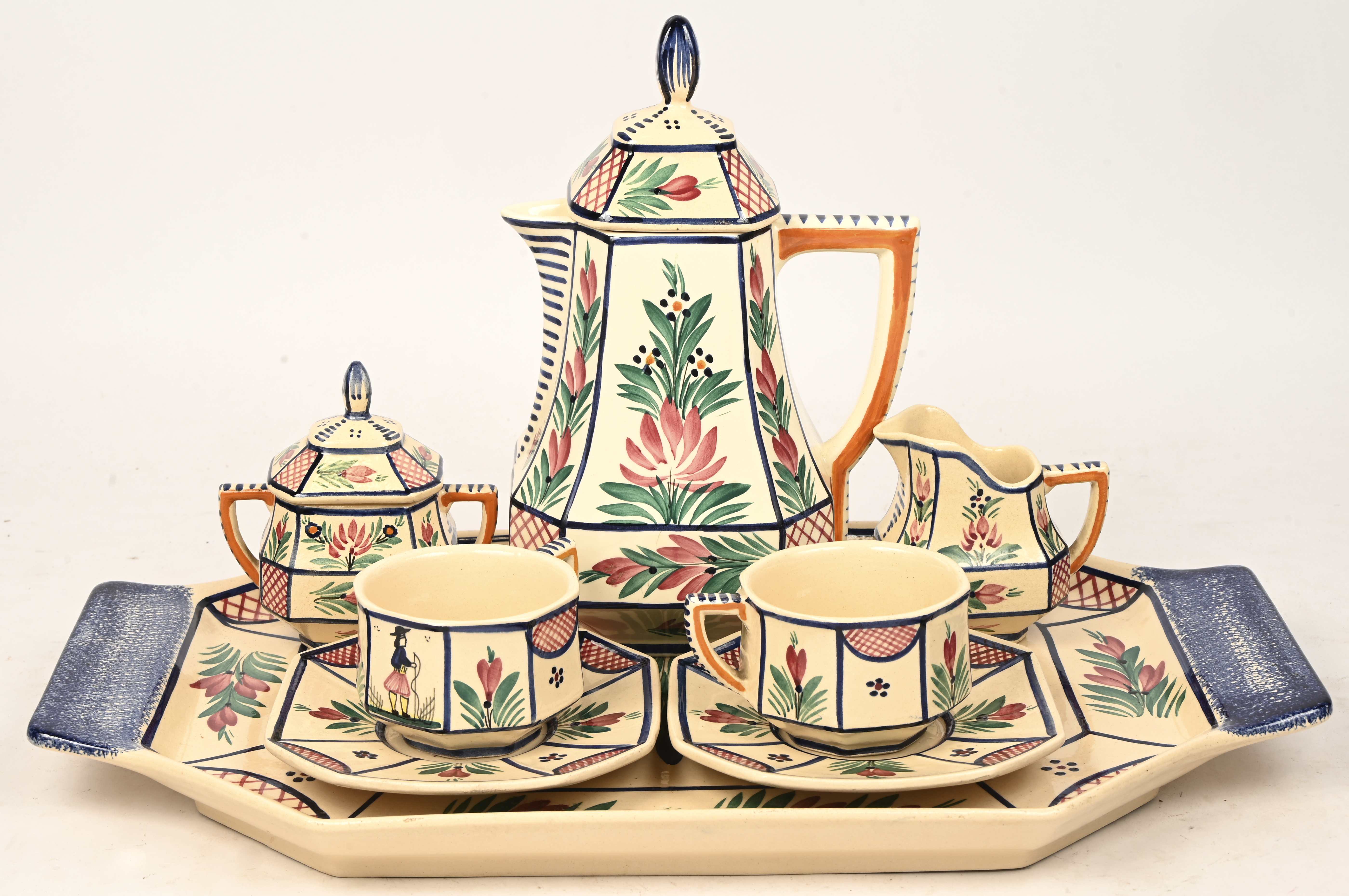 Een tête à tête koffieservies van meerkleurig Bretoens aardewerk, met bijhorend dienblad. Gemerkt HB, Quimper, France Een tête à tête koffieservies van meerkleurig Bretoens aardewerk, met bijhorend dienblad. Gemerkt HB, Quimper, France.