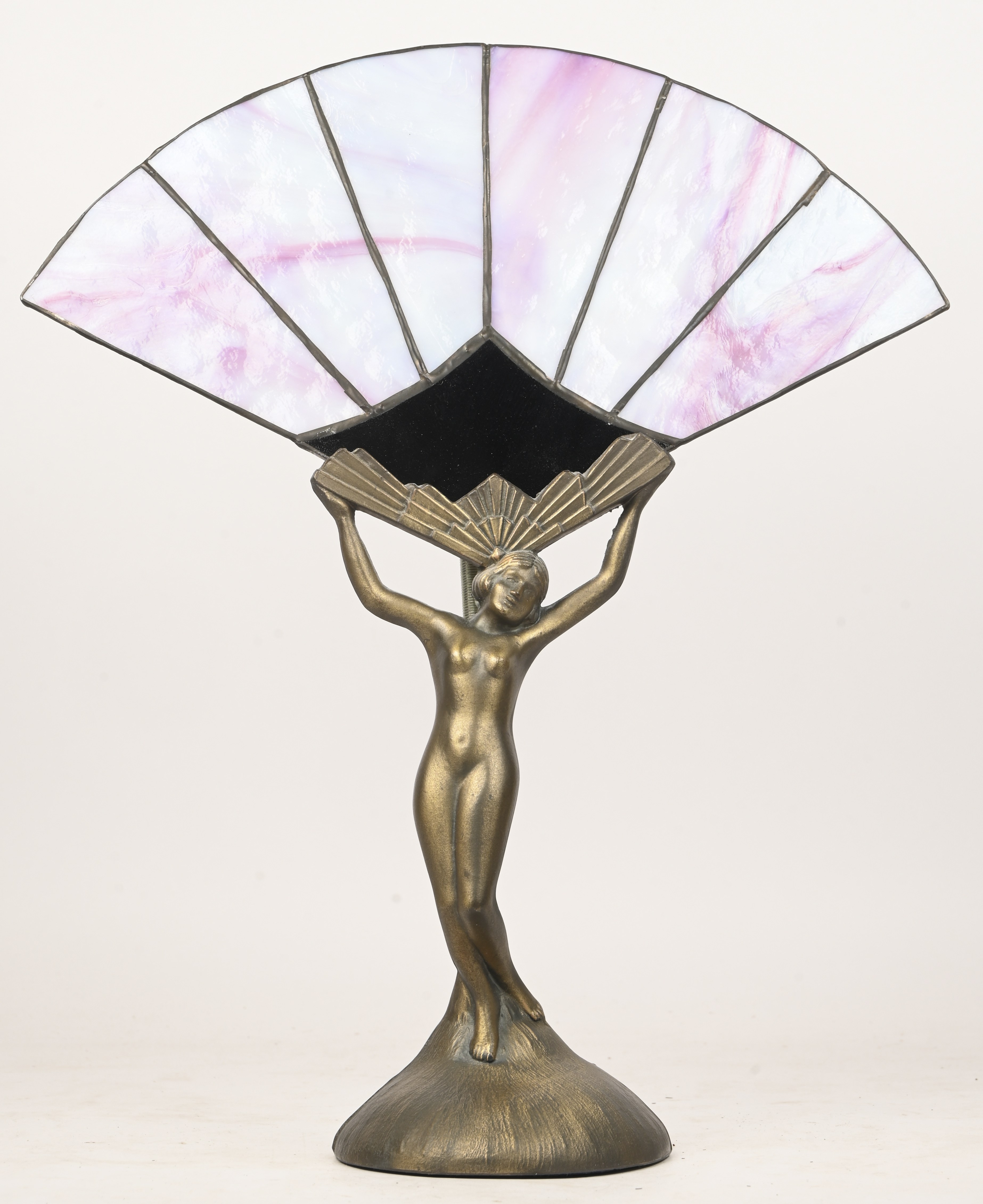 Een tafellamp in de vorm van een naakte vrouw met een waaier. Van koper en glas in lood, stijl art-deco Een tafellamp in de vorm van een naakte vrouw met een waaier. Van koper en glas in lood, stijl art-deco.