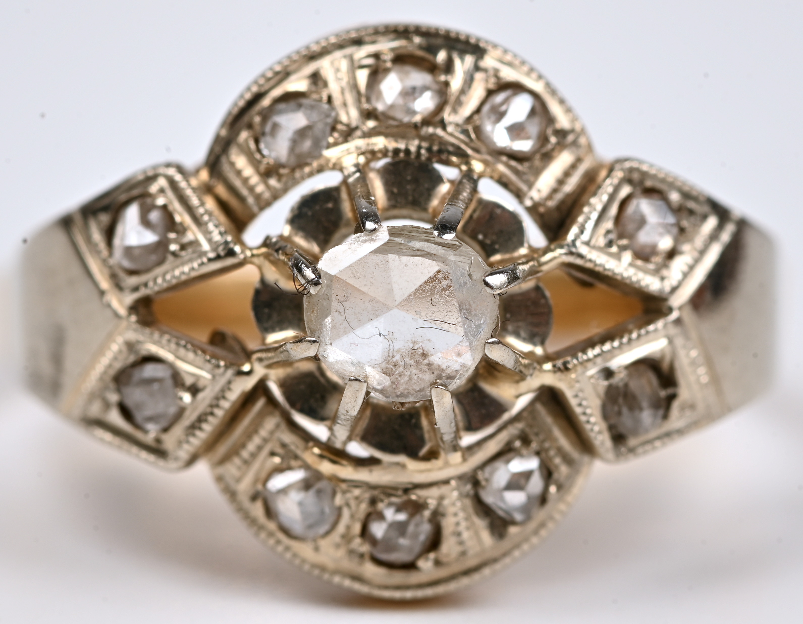 Een 18 kt wit en geelgouden art nouveau ring bezet met diamanten oude slijp met een gezamenlijk gewicht van +- 0,30 ct Een 18 kt wit en geelgouden art nouveau ring bezet met diamanten oude slijp met een gezamenlijk gewicht van +- 0,30 ct.