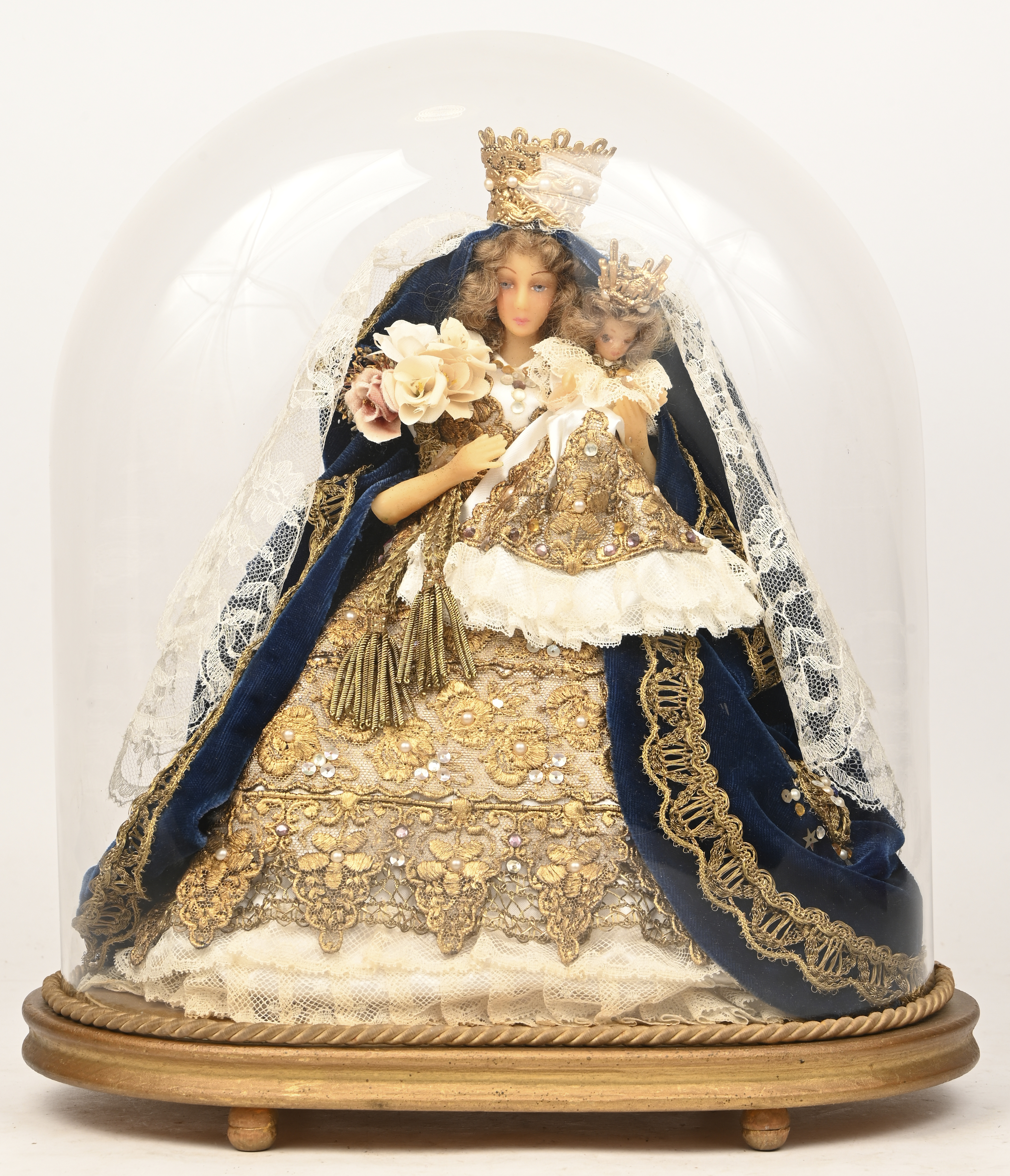 Een wassen Madonna onder een ovalen glazen stolp Een wassen Madonna onder een ovalen glazen stolp.