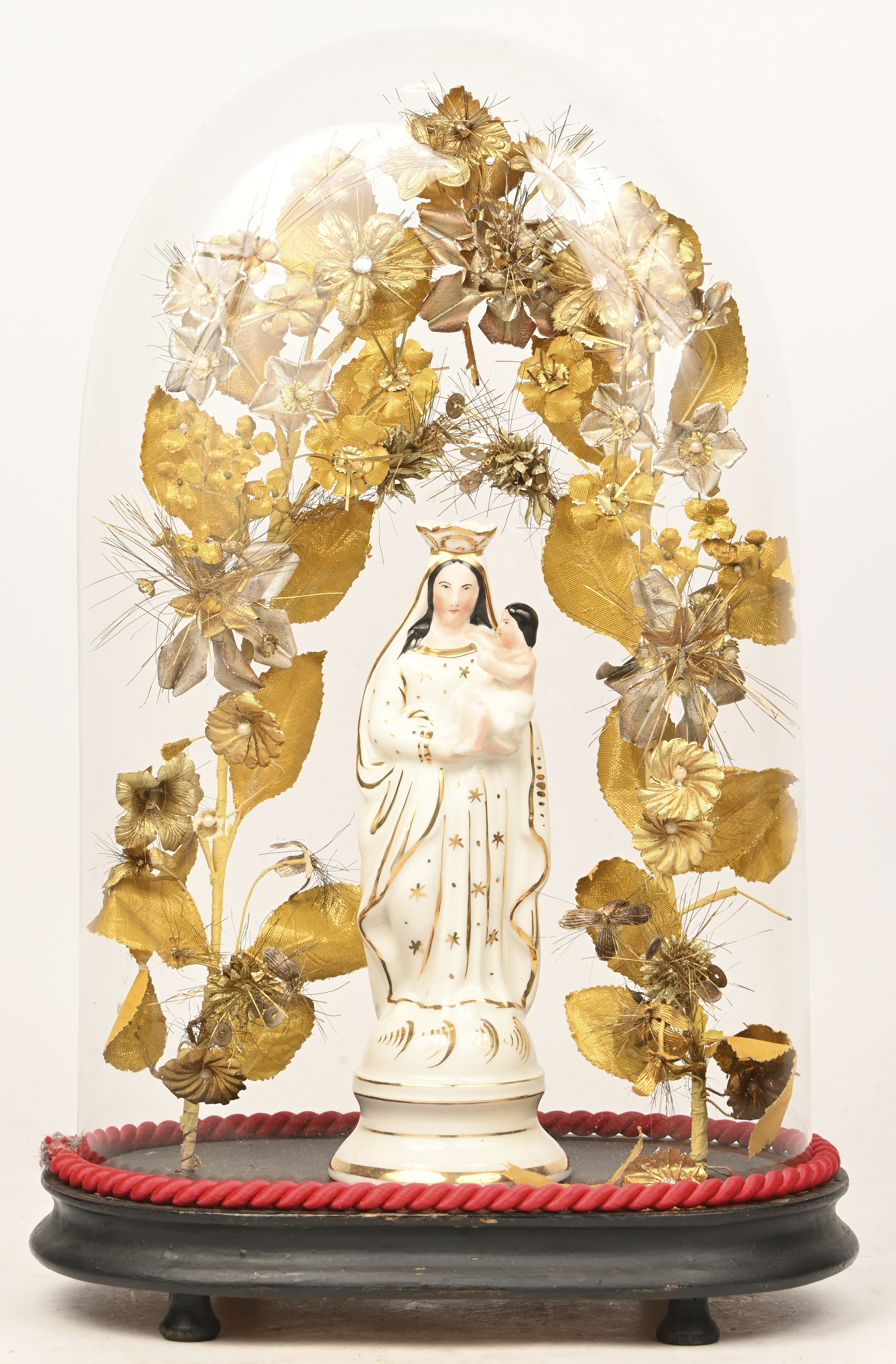 Een oude ovalen stolp met hierin een Madonna in Brussels porselein Een oude ovalen stolp met hierin een Madonna in Brussels porselein.