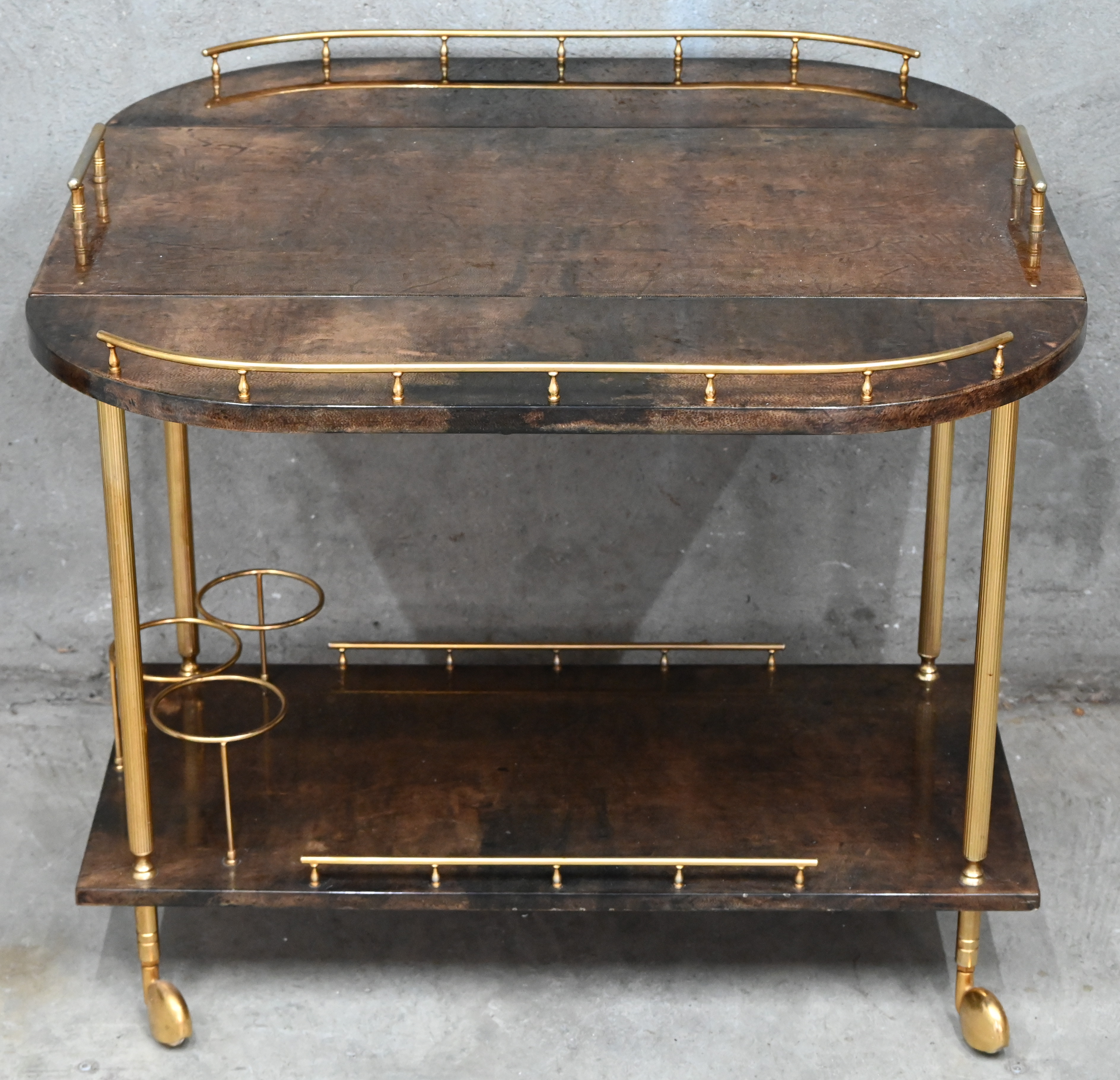 Een midcentury-modern bar-cart door Aldo Tura, Milano, Italy in gelakt geitenleder en verguld metaal Een midcentury-modern bar-cart door Aldo Tura, Milano, Italy in gelakt geitenleder en verguld metaal.