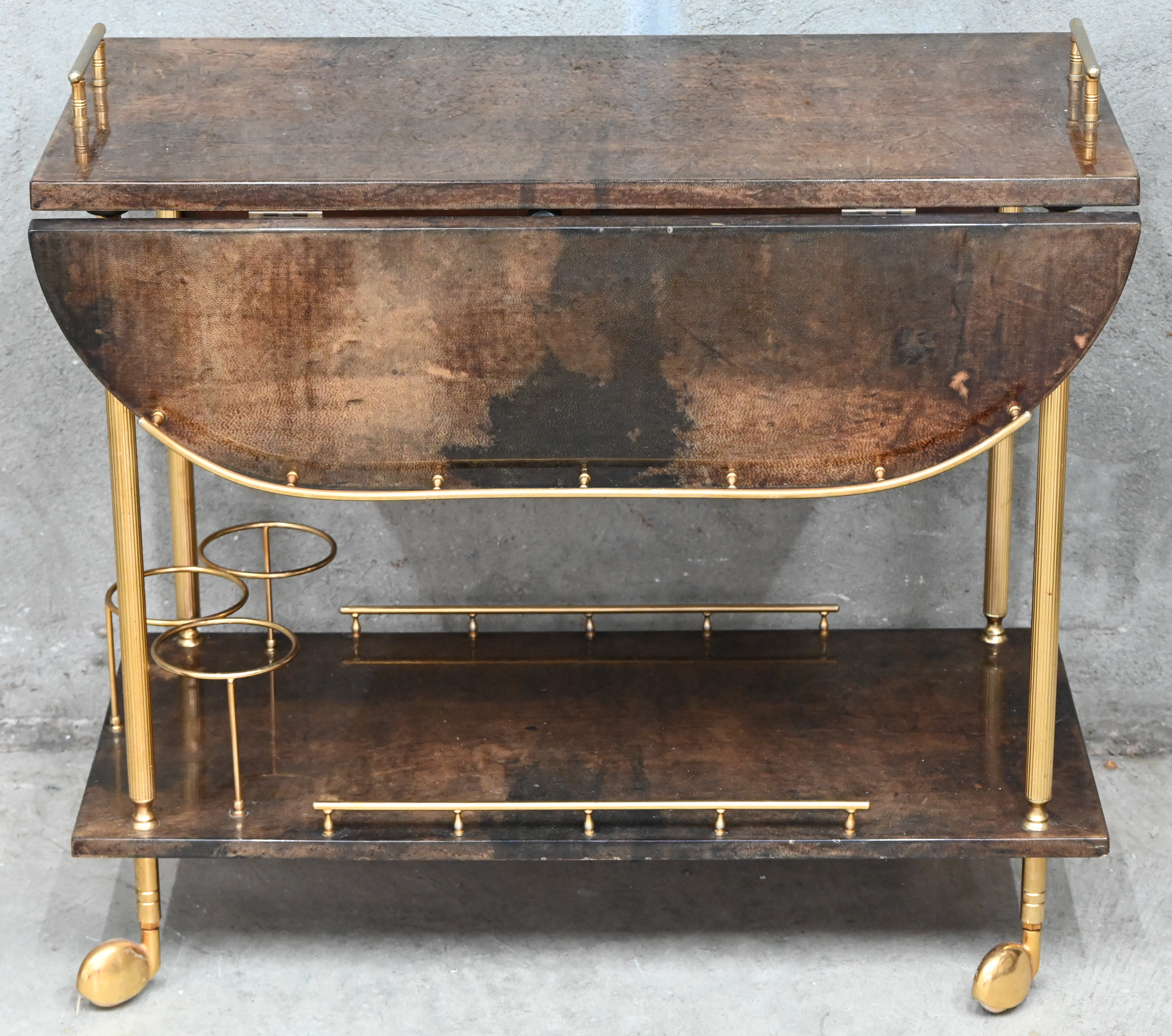 Een midcentury-modern bar-cart door Aldo Tura, Milano, Italy in gelakt geitenleder en verguld metaal Een midcentury-modern bar-cart door Aldo Tura, Milano, Italy in gelakt geitenleder en verguld metaal.