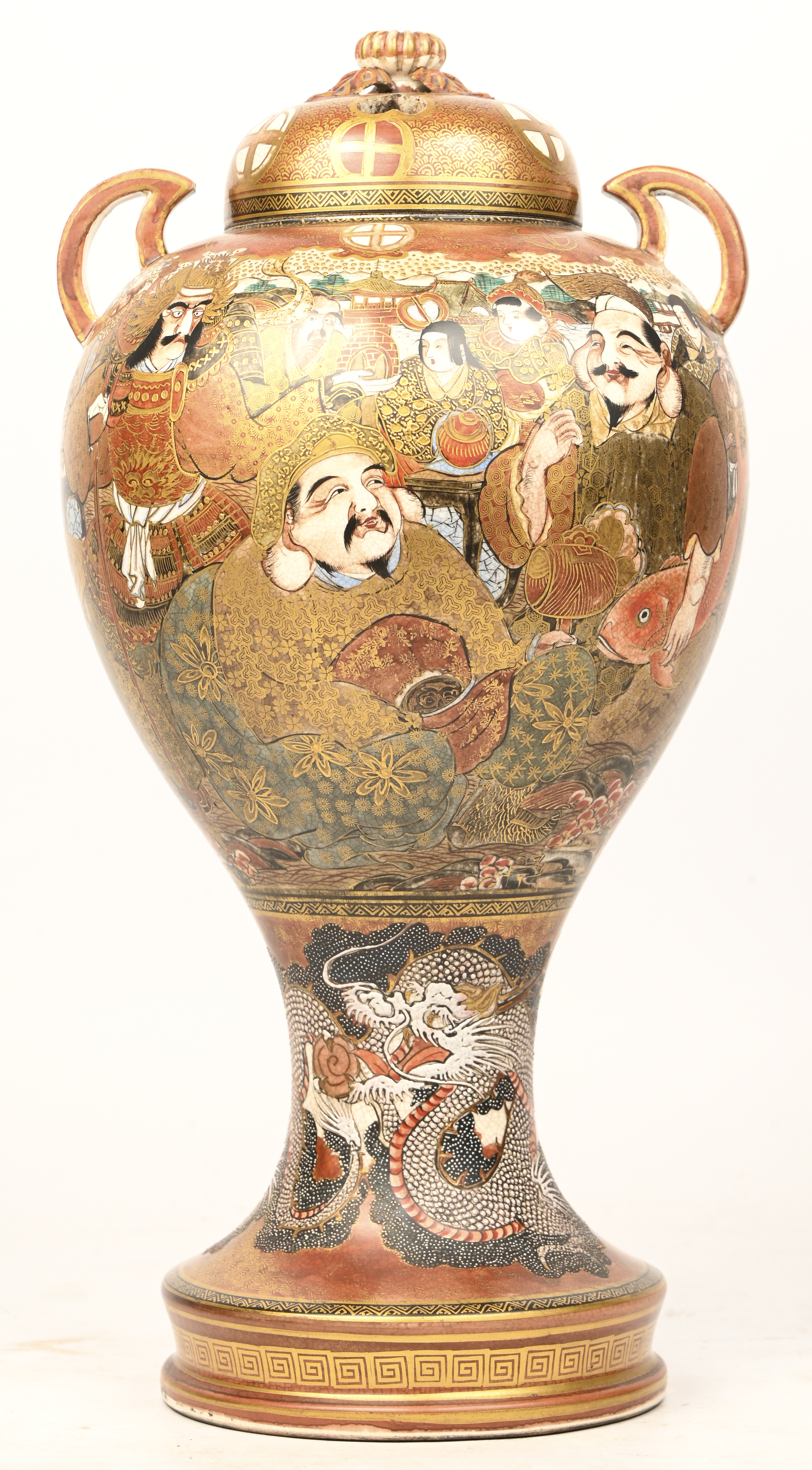 Een laat 19e eeuwse Satsuma dekselvaas met verguld decor van karikaturen en onderaan een draak in reliëf Een laat 19e eeuwse Satsuma dekselvaas met verguld decor van karikaturen en onderaan een draak in reliëf.