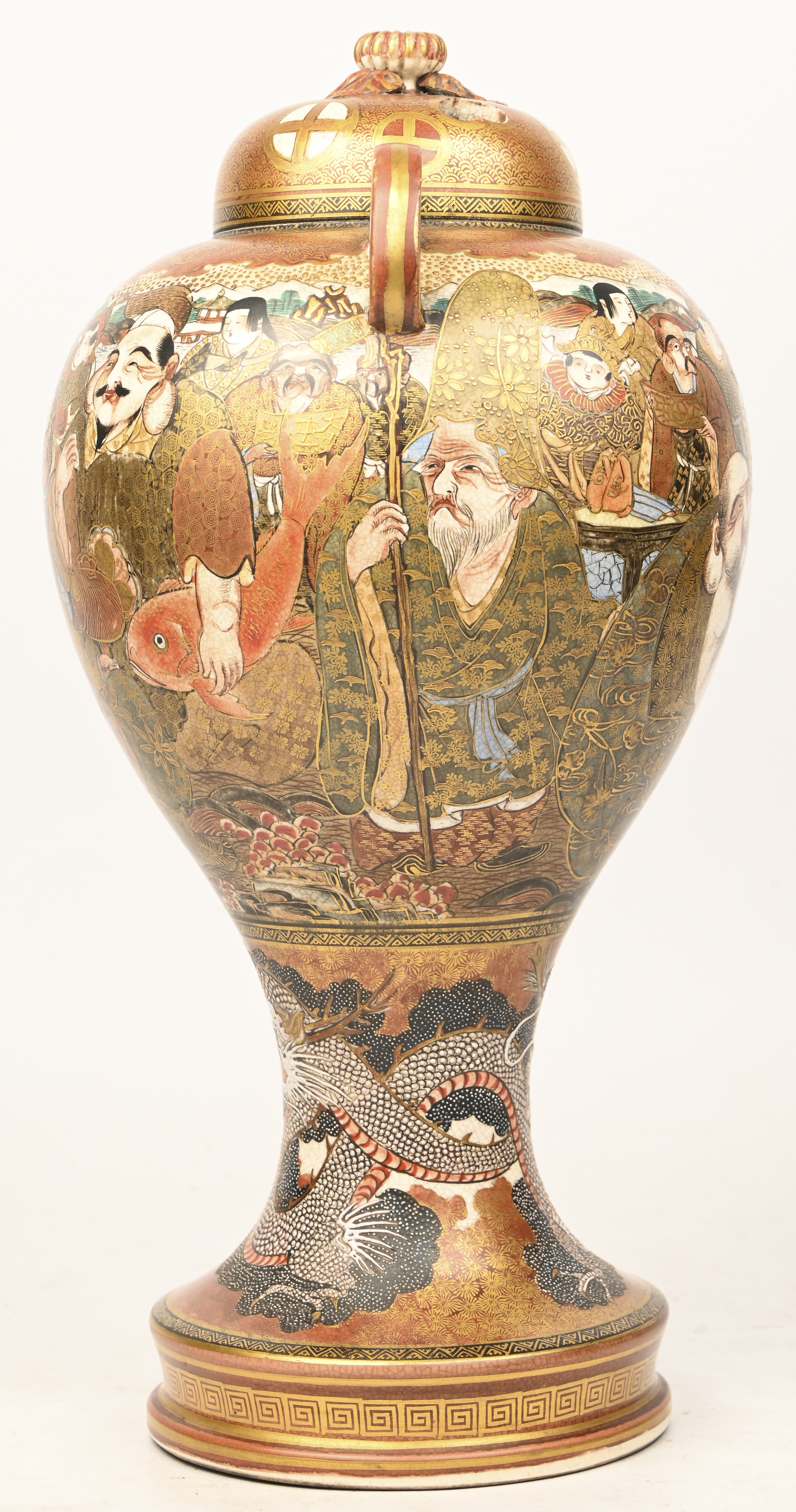 Een laat 19e eeuwse Satsuma dekselvaas met verguld decor van karikaturen en onderaan een draak in reliëf Een laat 19e eeuwse Satsuma dekselvaas met verguld decor van karikaturen en onderaan een draak in reliëf.