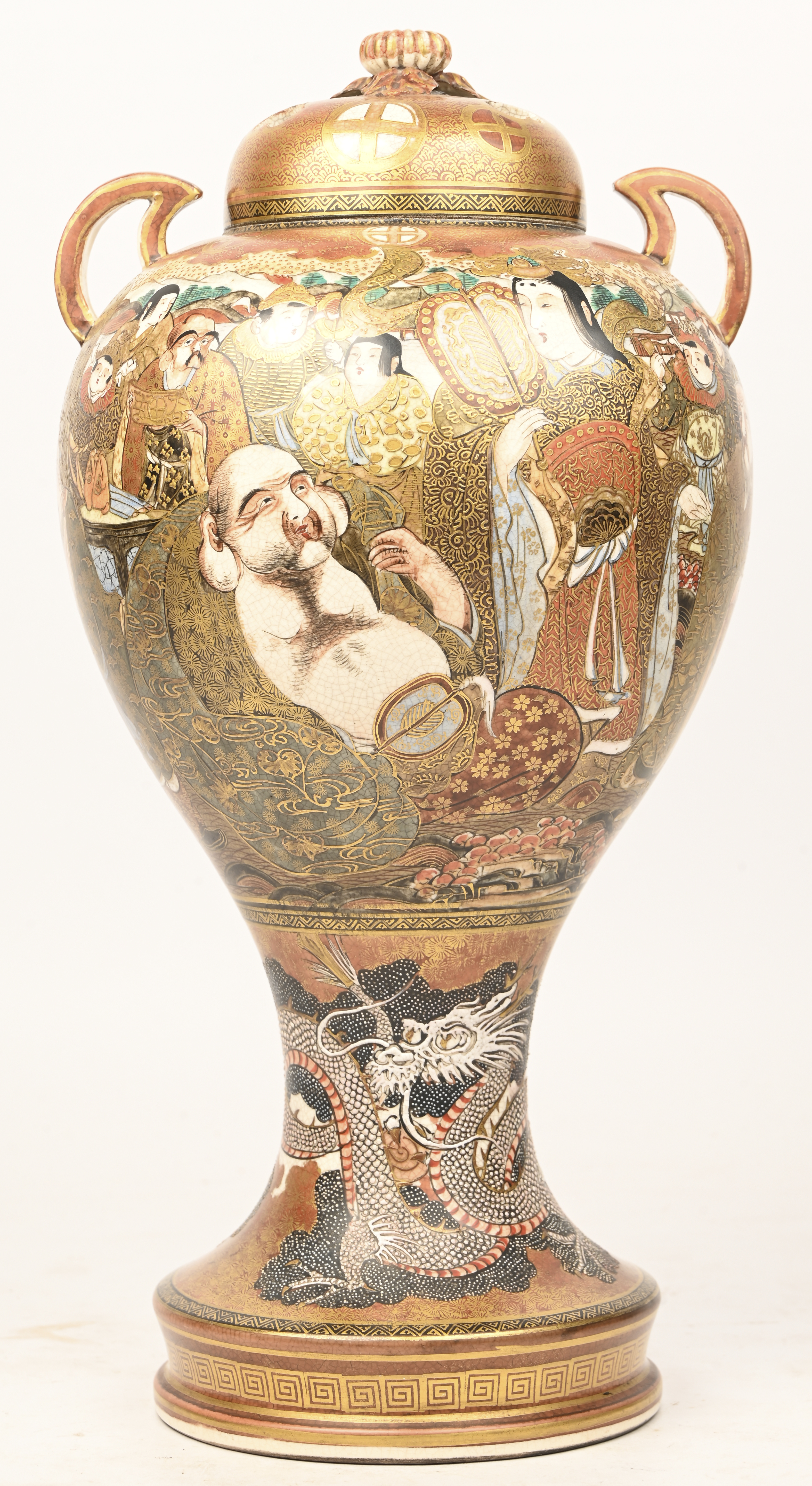 Een laat 19e eeuwse Satsuma dekselvaas met verguld decor van karikaturen en onderaan een draak in reliëf Een laat 19e eeuwse Satsuma dekselvaas met verguld decor van karikaturen en onderaan een draak in reliëf.