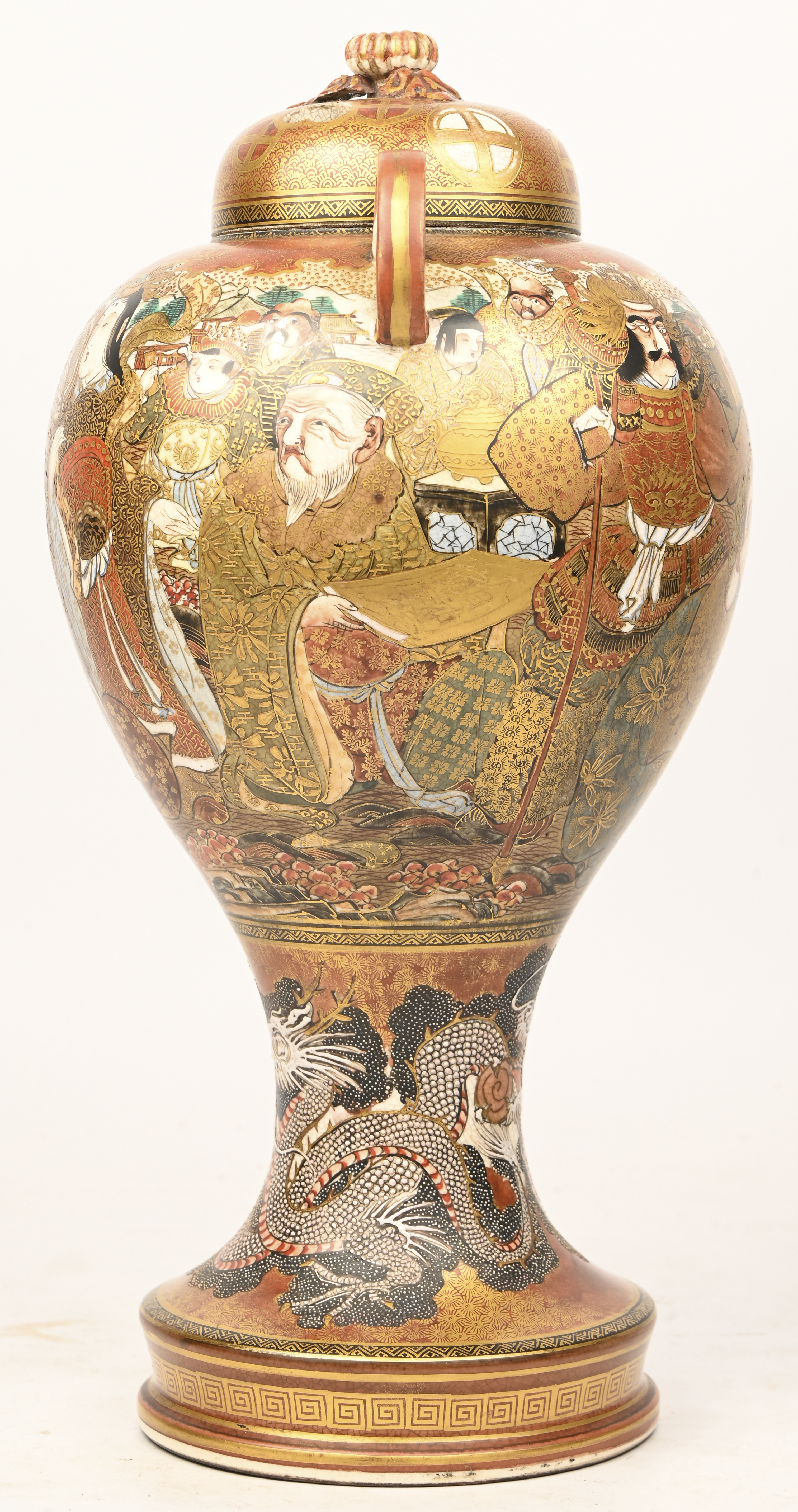 Een laat 19e eeuwse Satsuma dekselvaas met verguld decor van karikaturen en onderaan een draak in reliëf Een laat 19e eeuwse Satsuma dekselvaas met verguld decor van karikaturen en onderaan een draak in reliëf.
