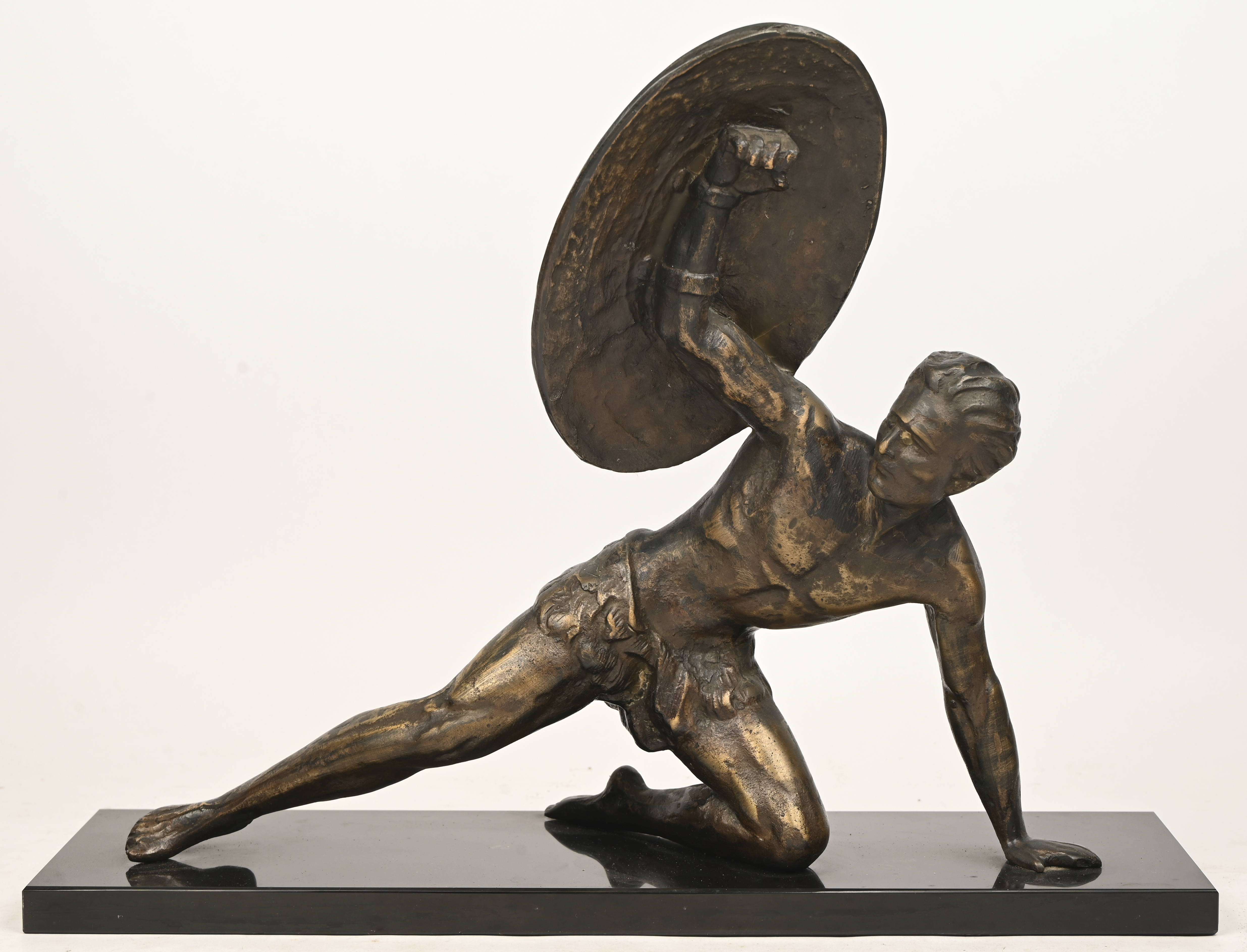 Een bronzen beeld van een Griekse krijger met schild. Op arduinen sokkel Een bronzen beeld van een Griekse krijger met schild. Op arduinen sokkel.