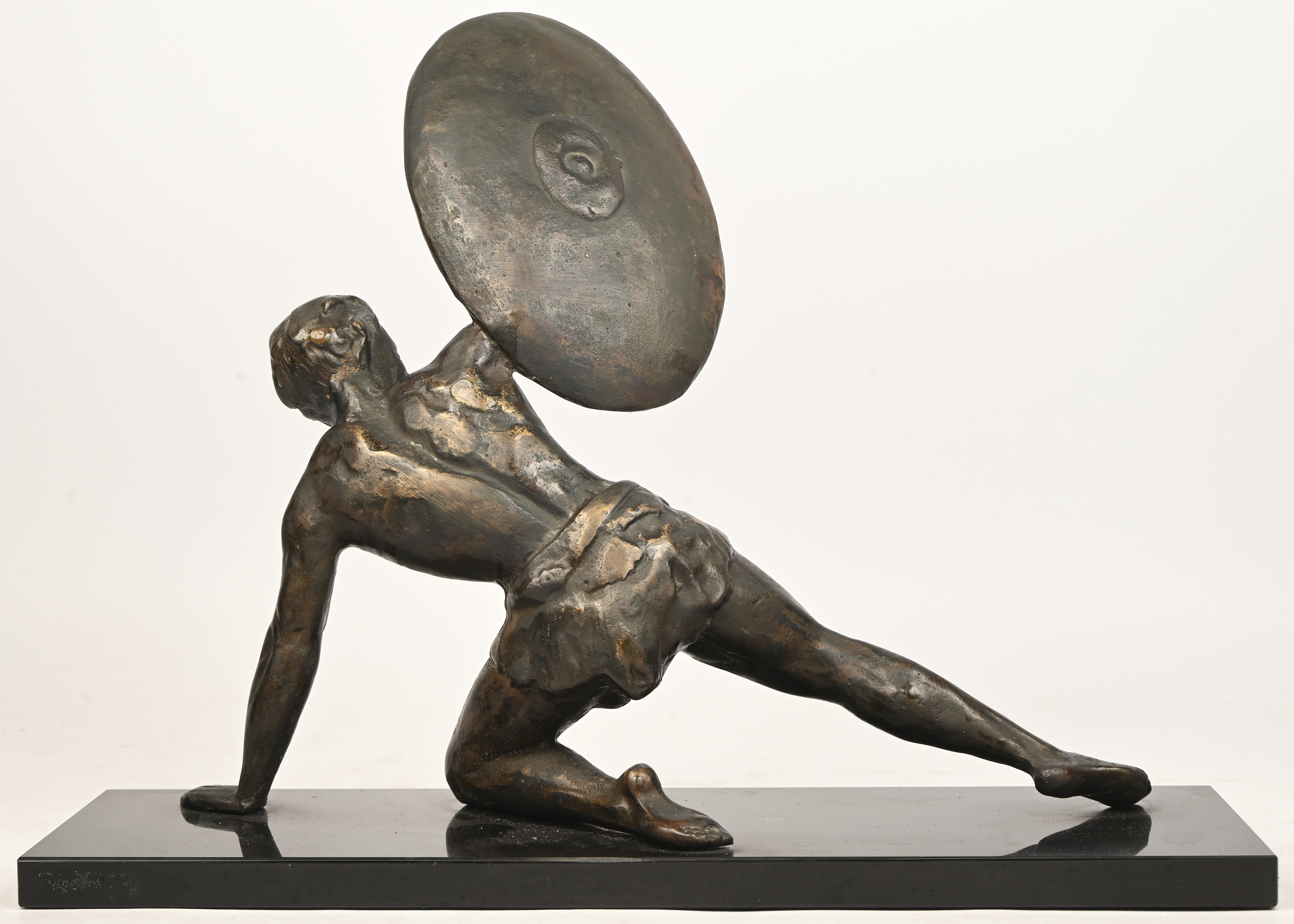 Een bronzen beeld van een Griekse krijger met schild. Op arduinen sokkel Een bronzen beeld van een Griekse krijger met schild. Op arduinen sokkel.