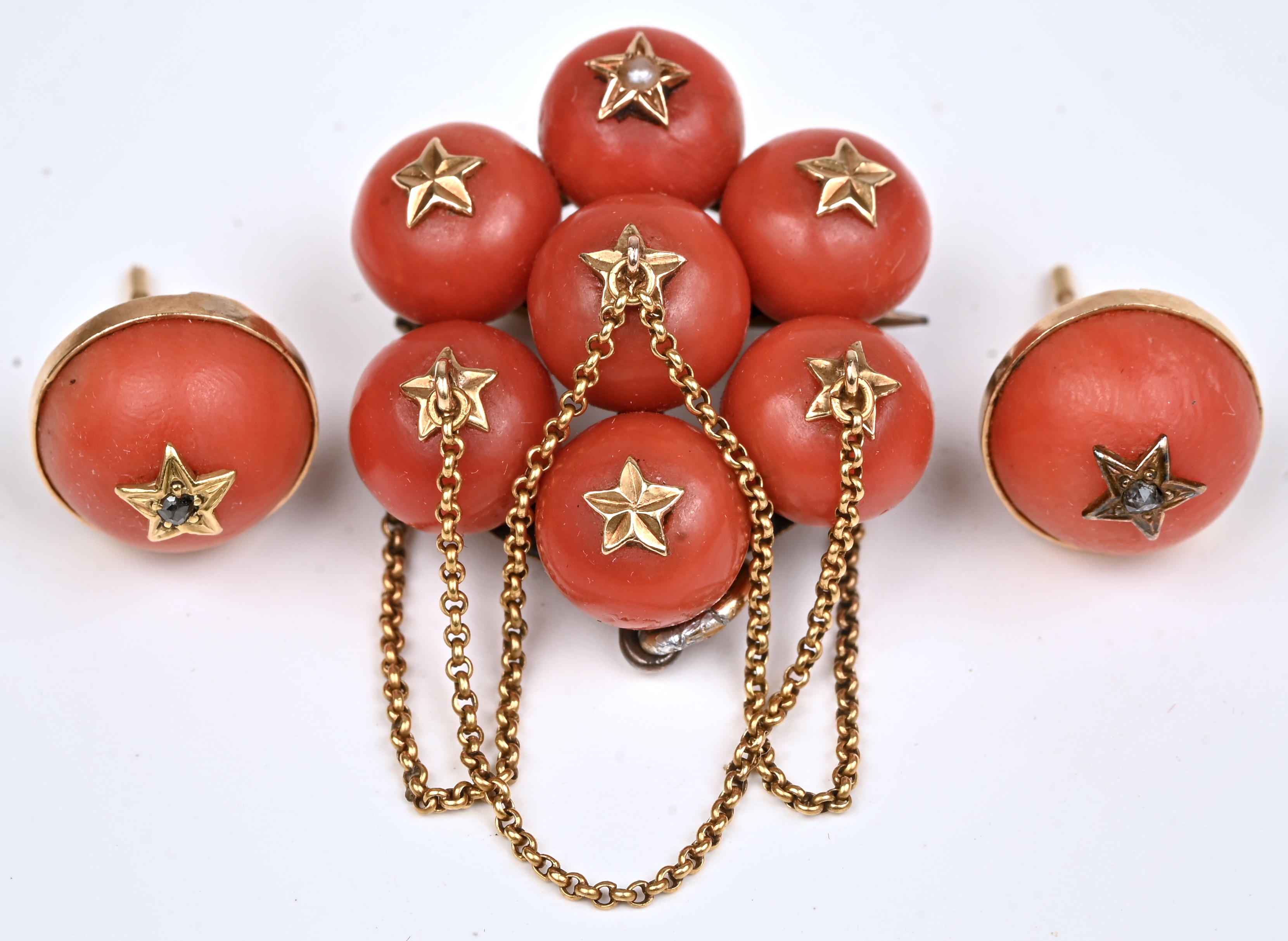 Een broche of hanger met twee oorbellen bezet met koraal van 18 kt geelgoud. Achterkant broche de speld alleen goud Een broche of hanger met twee oorbellen bezet met koraal van 18 kt geelgoud. Achterkant broche de speld alleen goud.
