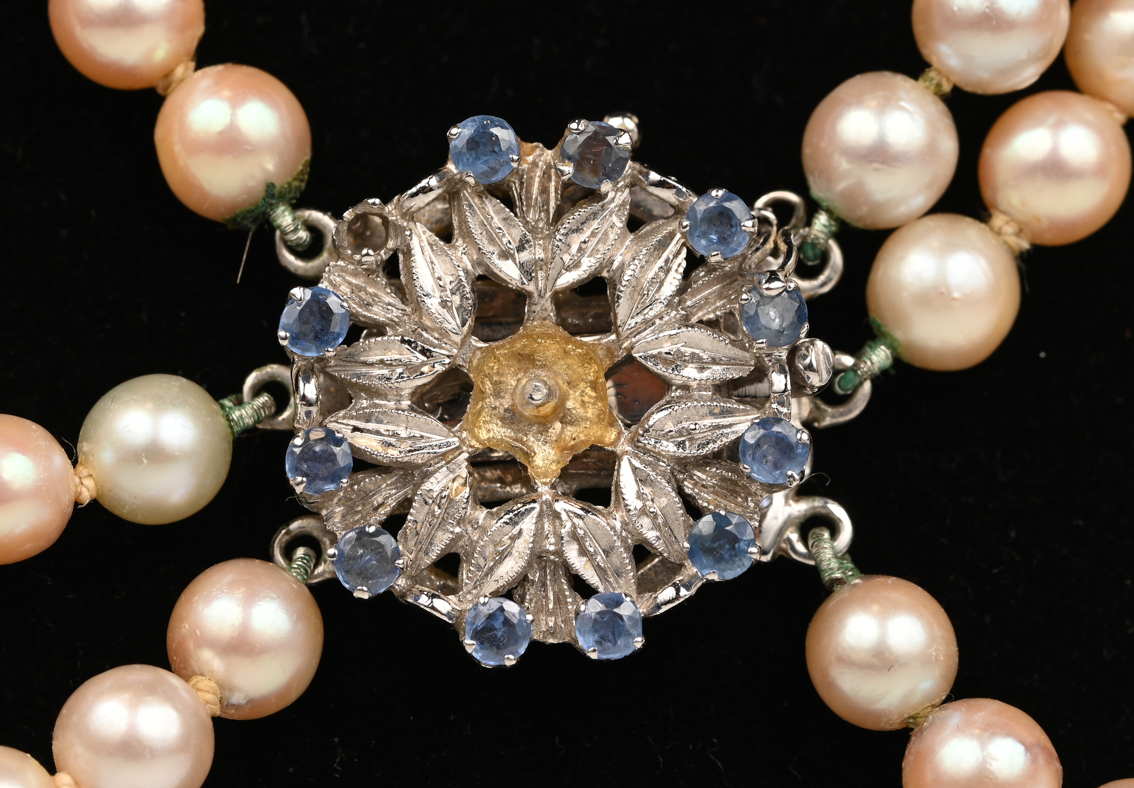 Een drie rijen parelhalssnoer met 18 witgouden slot bezet met saffier. (twee steentjes ontbreken) Een drie rijen parelhalssnoer met 18 witgouden slot bezet met saffier. (twee steentjes ontbreken).