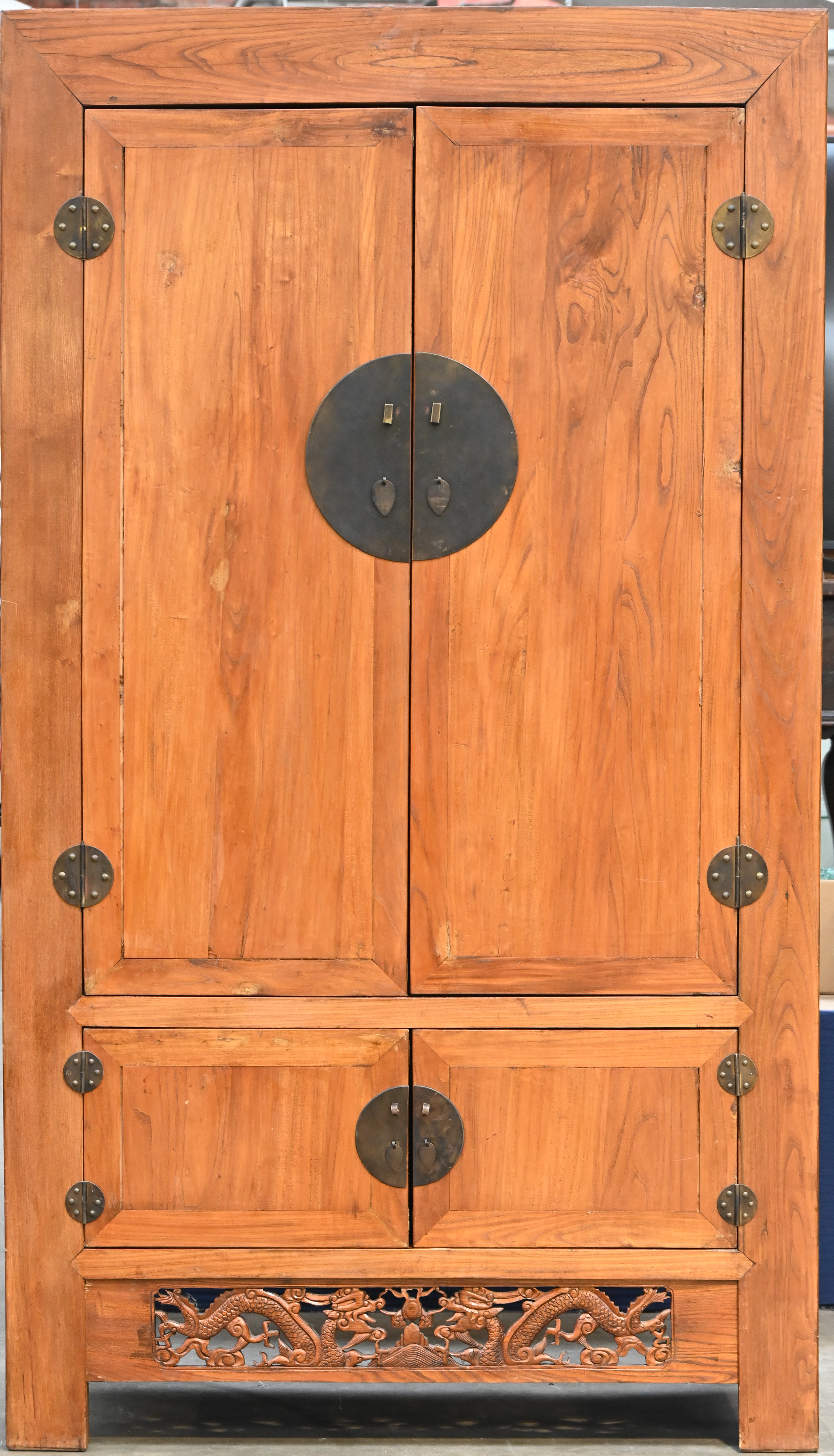 Een sobere legkast in Chinese stijl met vier deuren. Onderaan een gesculpteerde fries met twee draken Een sobere legkast in Chinese stijl met vier deuren. Onderaan een gesculpteerde fries met twee draken.