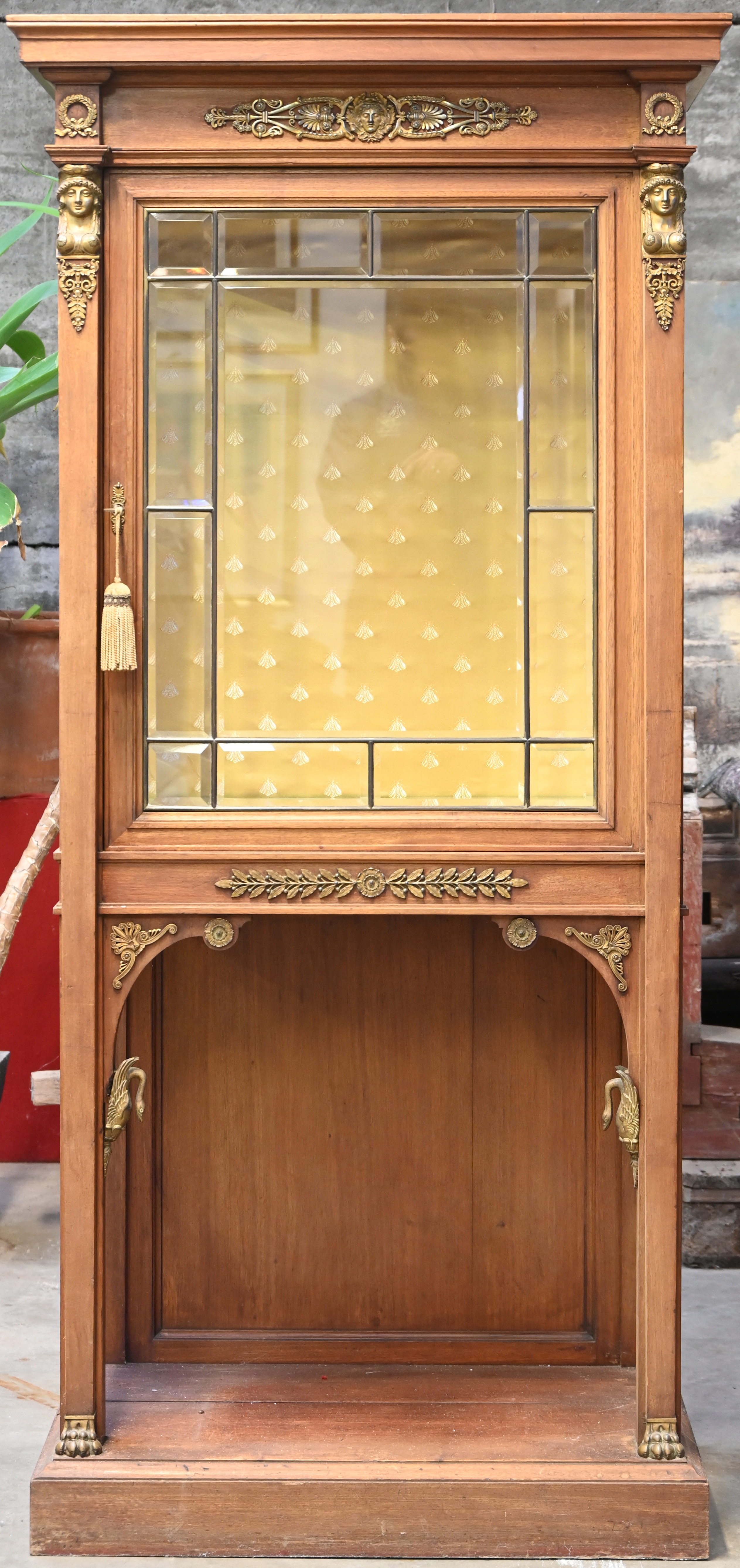 Een ééndeurs vitrinekast met geslepen glas in Empire stijl Een ééndeurs vitrinekast met geslepen glas in Empire stijl.